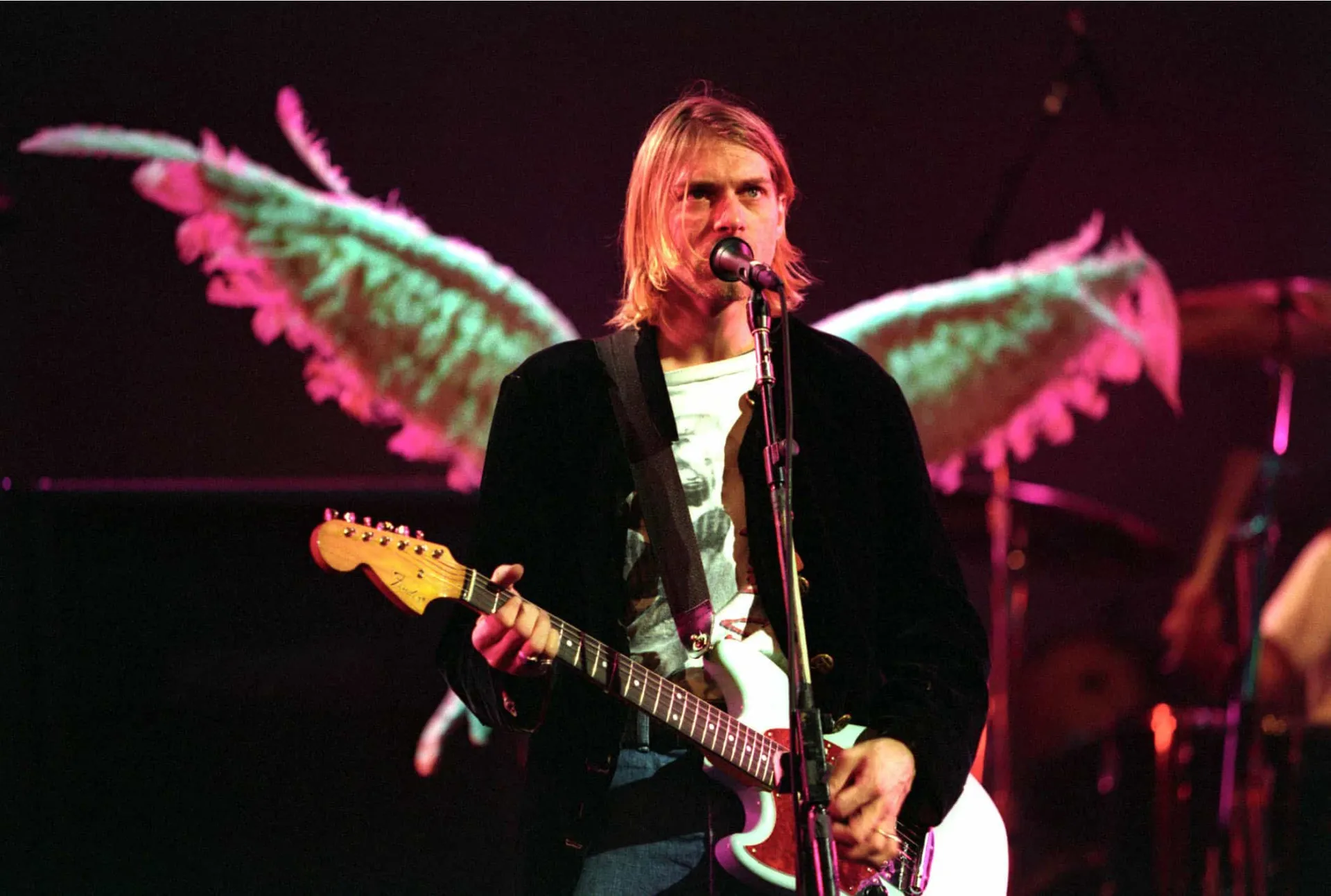 Kurt Cobain, vocalista do Nirvana, tocando guitarra e cantando com intensidade.