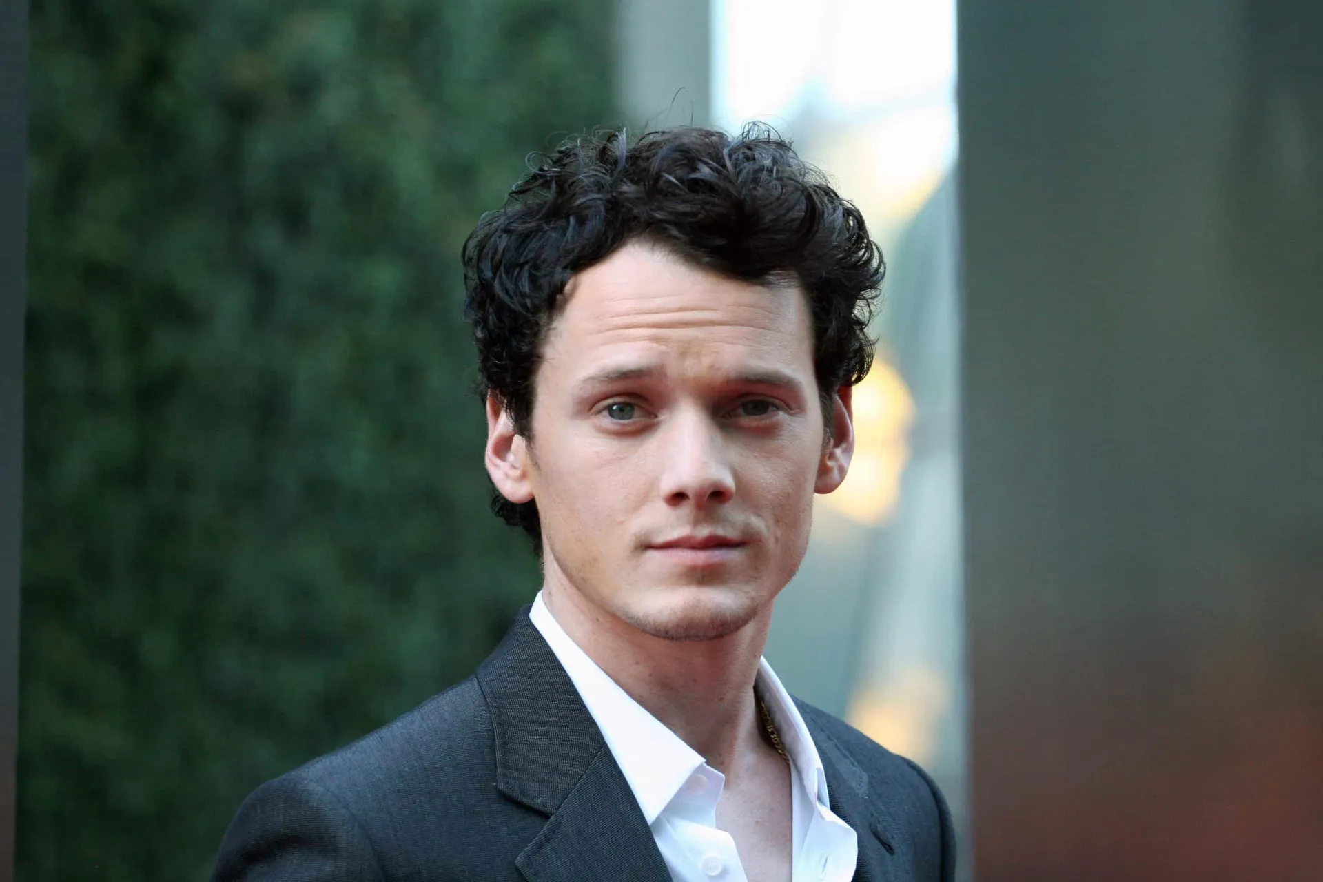 O ator Anton Yelchin sorrindo em um evento de tapete vermelho.