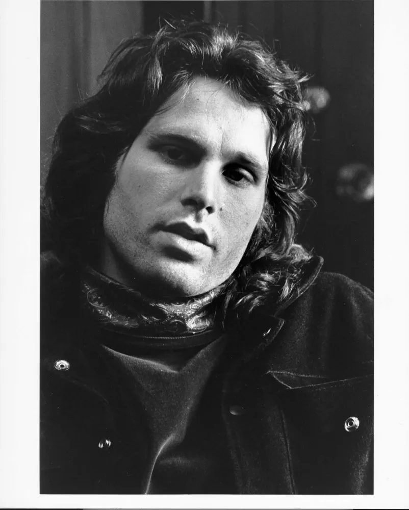 Retrato icônico de Jim Morrison, vocalista do The Doors, olhando intensamente para a câmera.