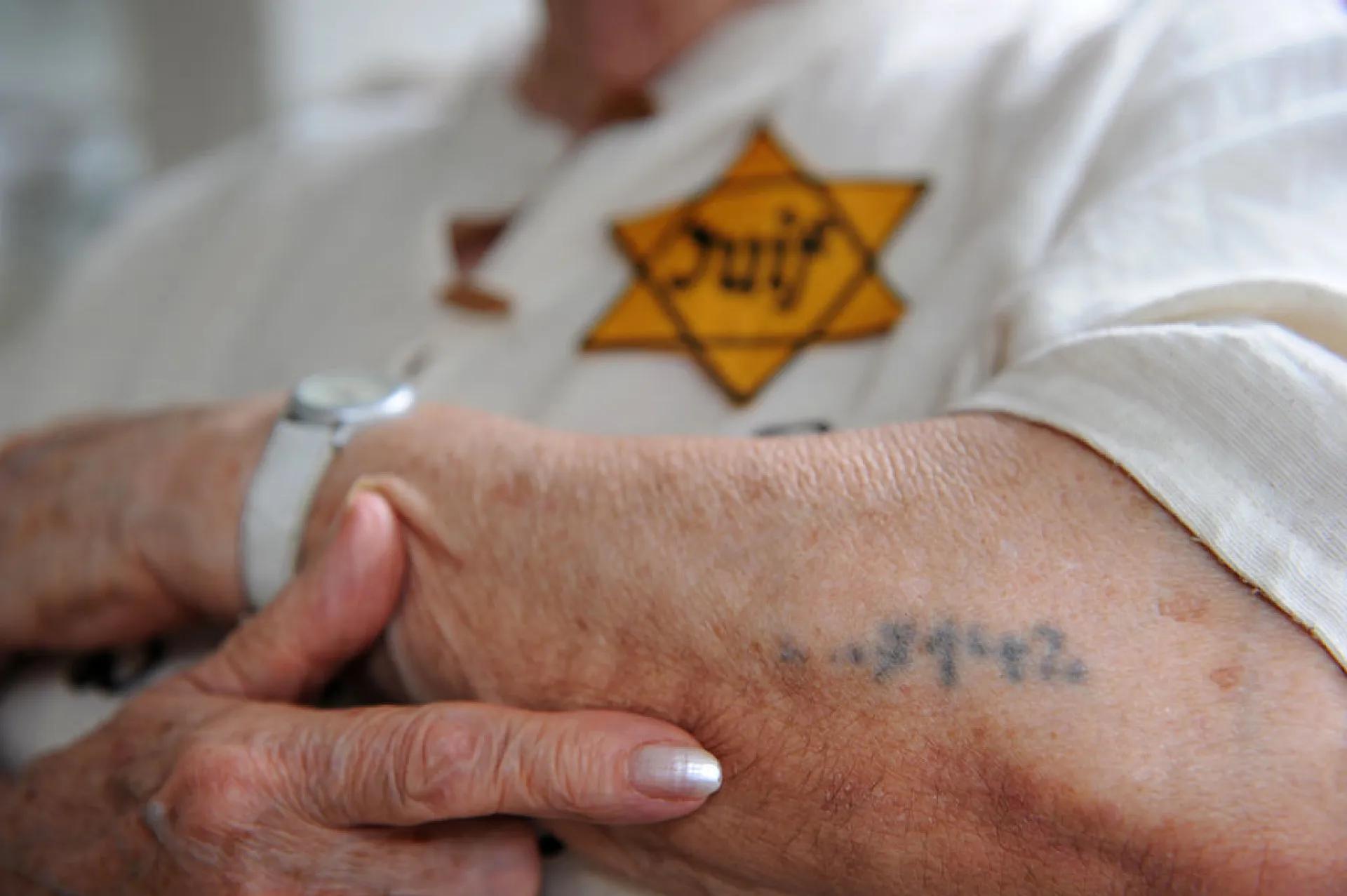 Braço de um sobrevivente do Holocausto com o número de identificação tatuado.