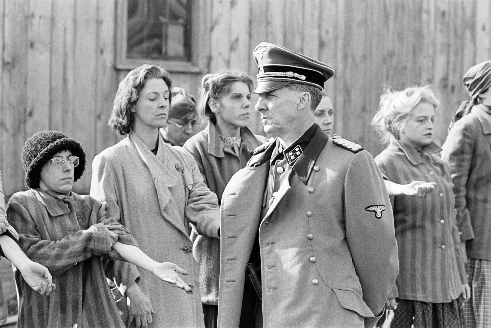 Prisioneiras em Auschwitz caminhando em fila, ilustrando a rotina diária de sobrevivência.