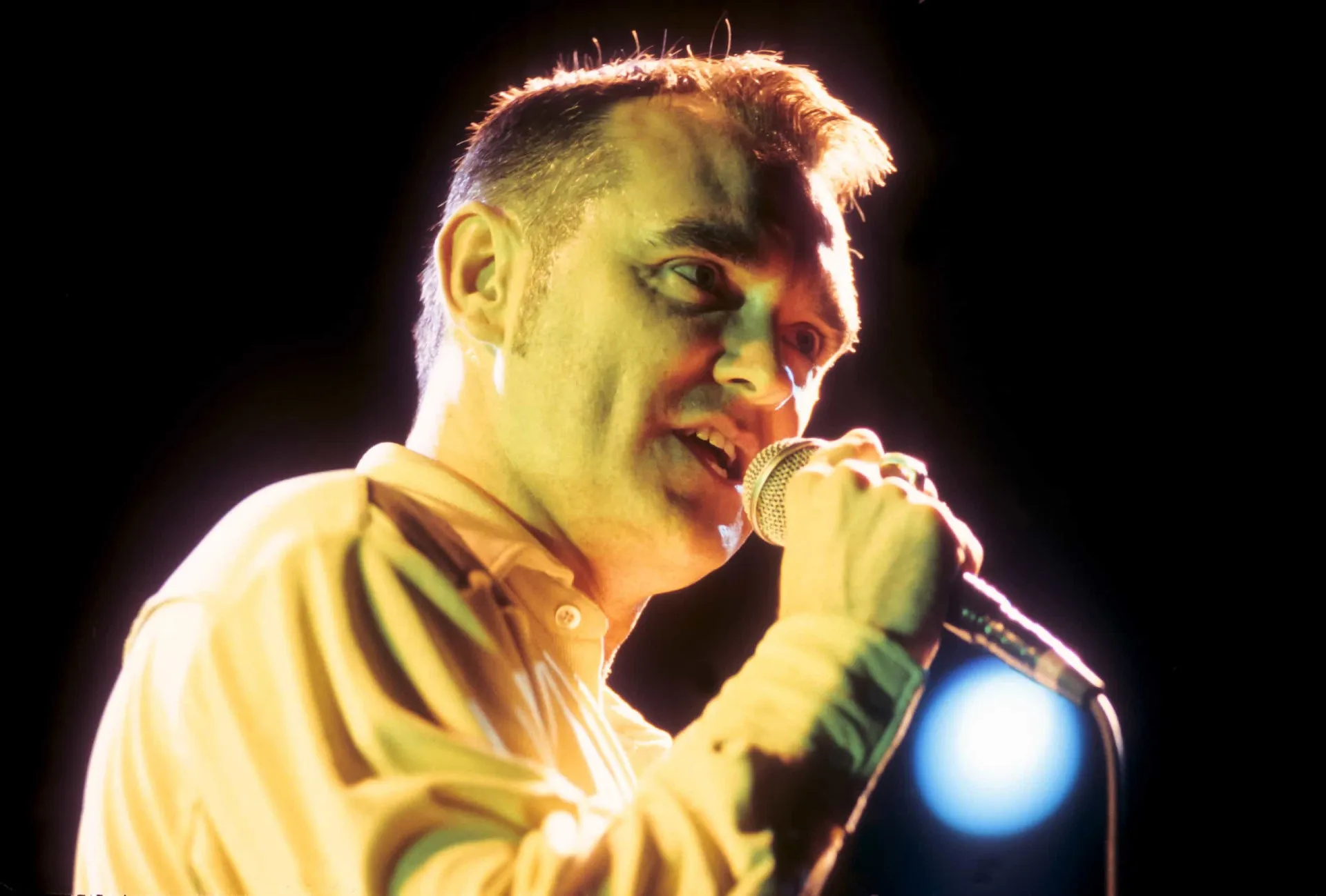 Morrissey, ex-vocalista do The Smiths, cantando com sua expressão melancólica característica.