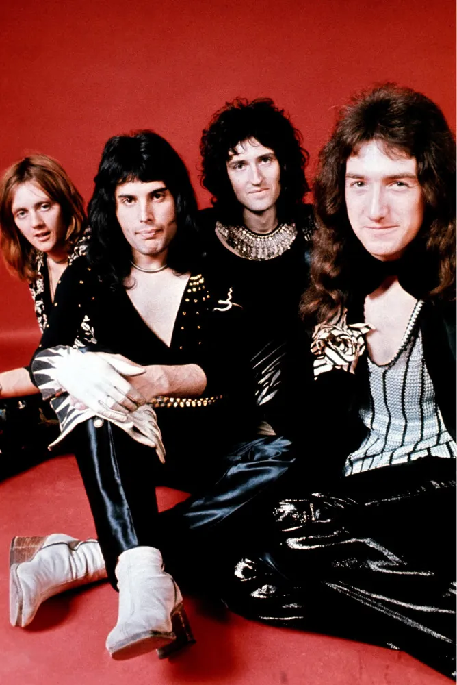 A icônica foto da banda Queen, com os rostos de Freddie Mercury, Brian May, Roger Taylor e John Deacon sobre um fundo preto.