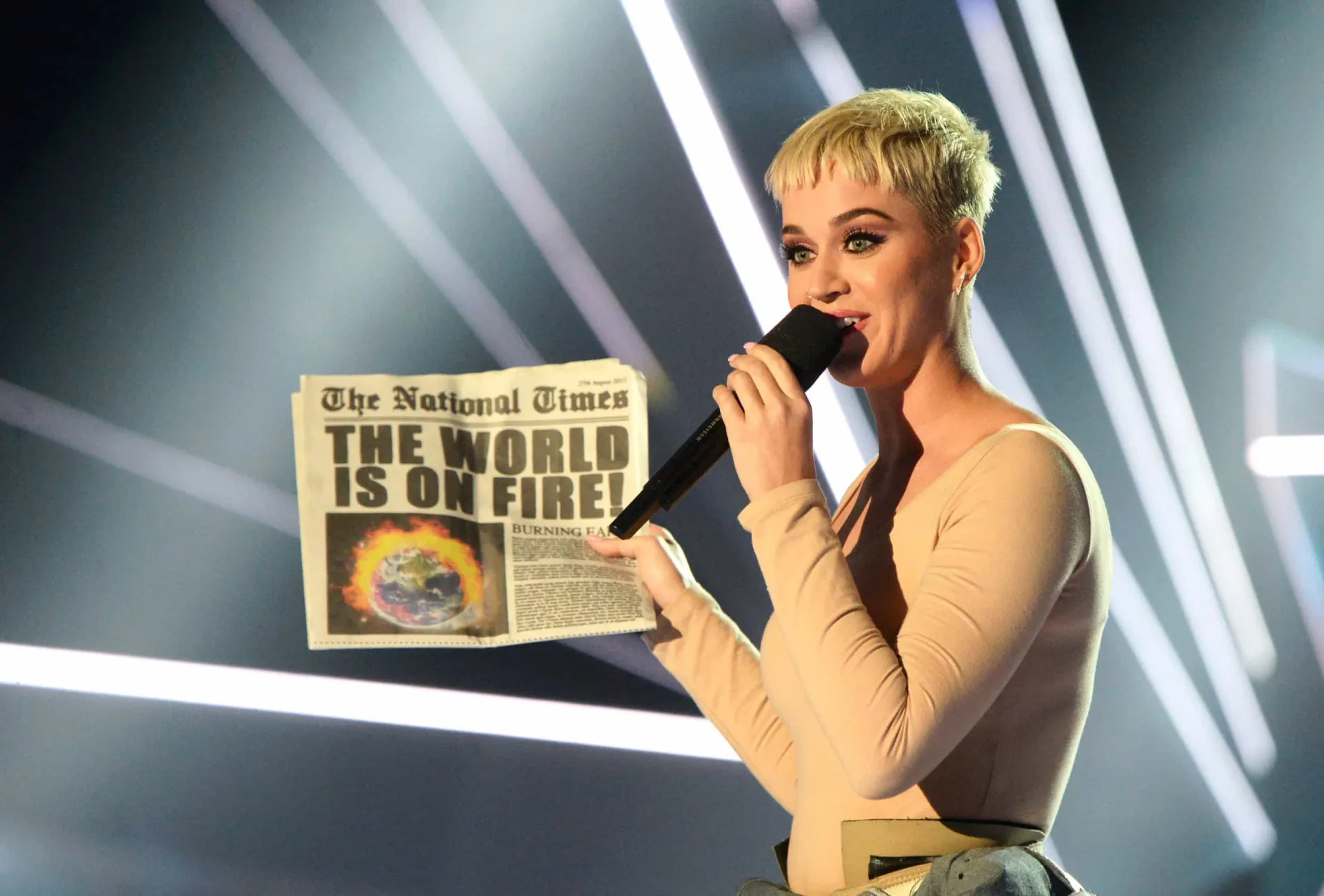 Katy Perry com cabelo curto e loiro, olhando seriamente para a câmera.