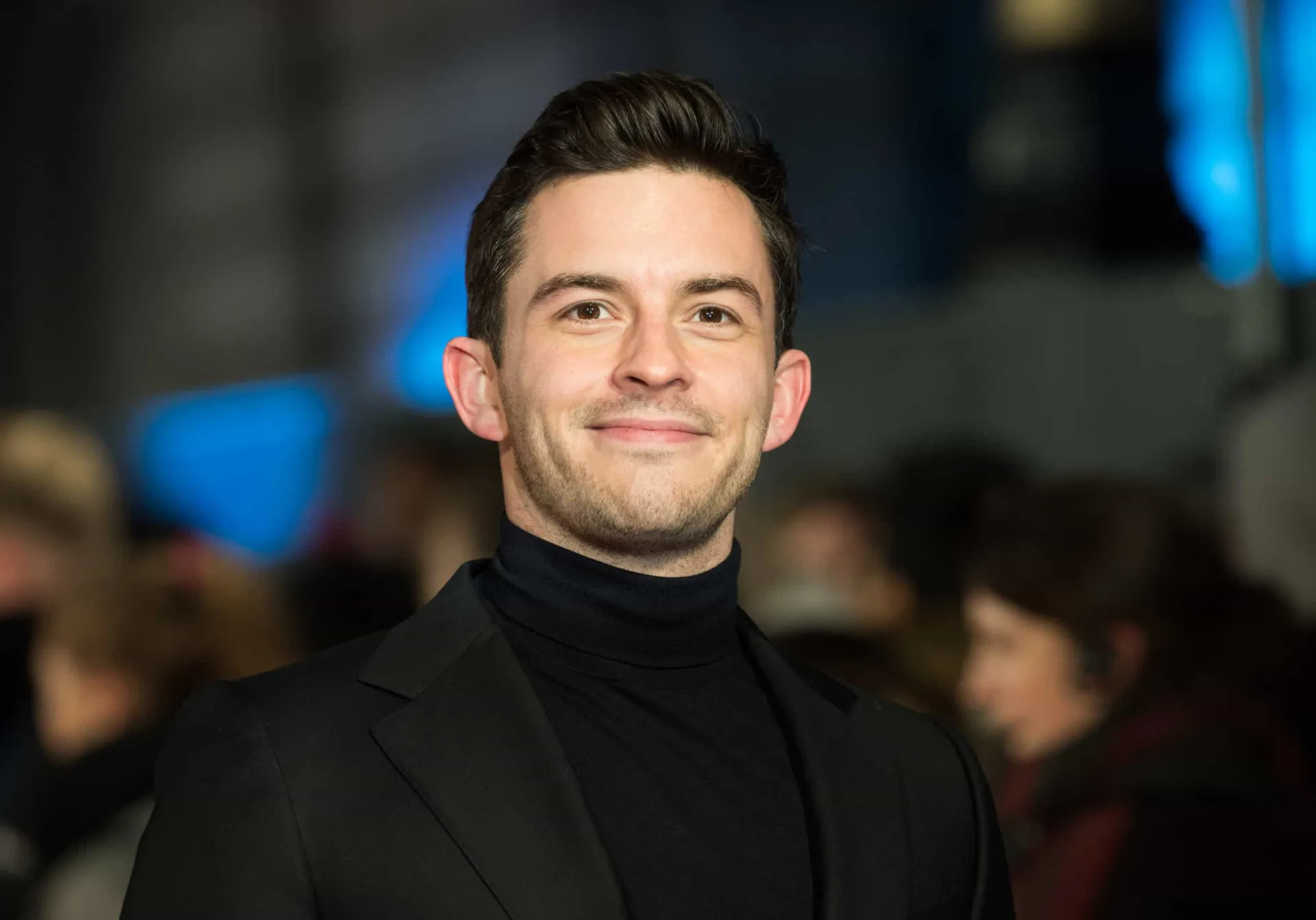 Jonathan Bailey, o Visconde de 'Bridgerton', com um sorriso charmoso.