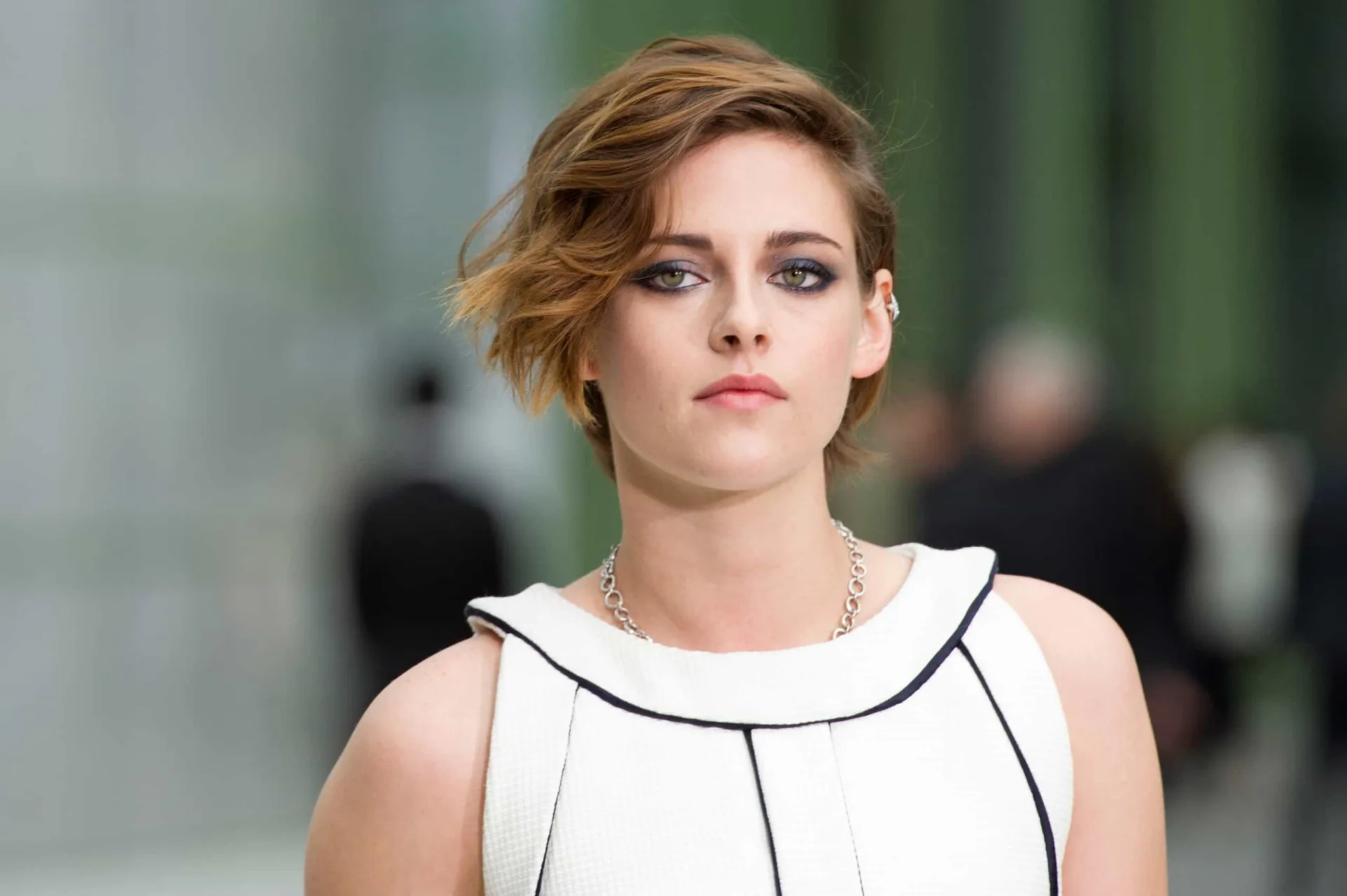 Kristen Stewart com seu estilo característico, olhando de forma intensa para a câmera.