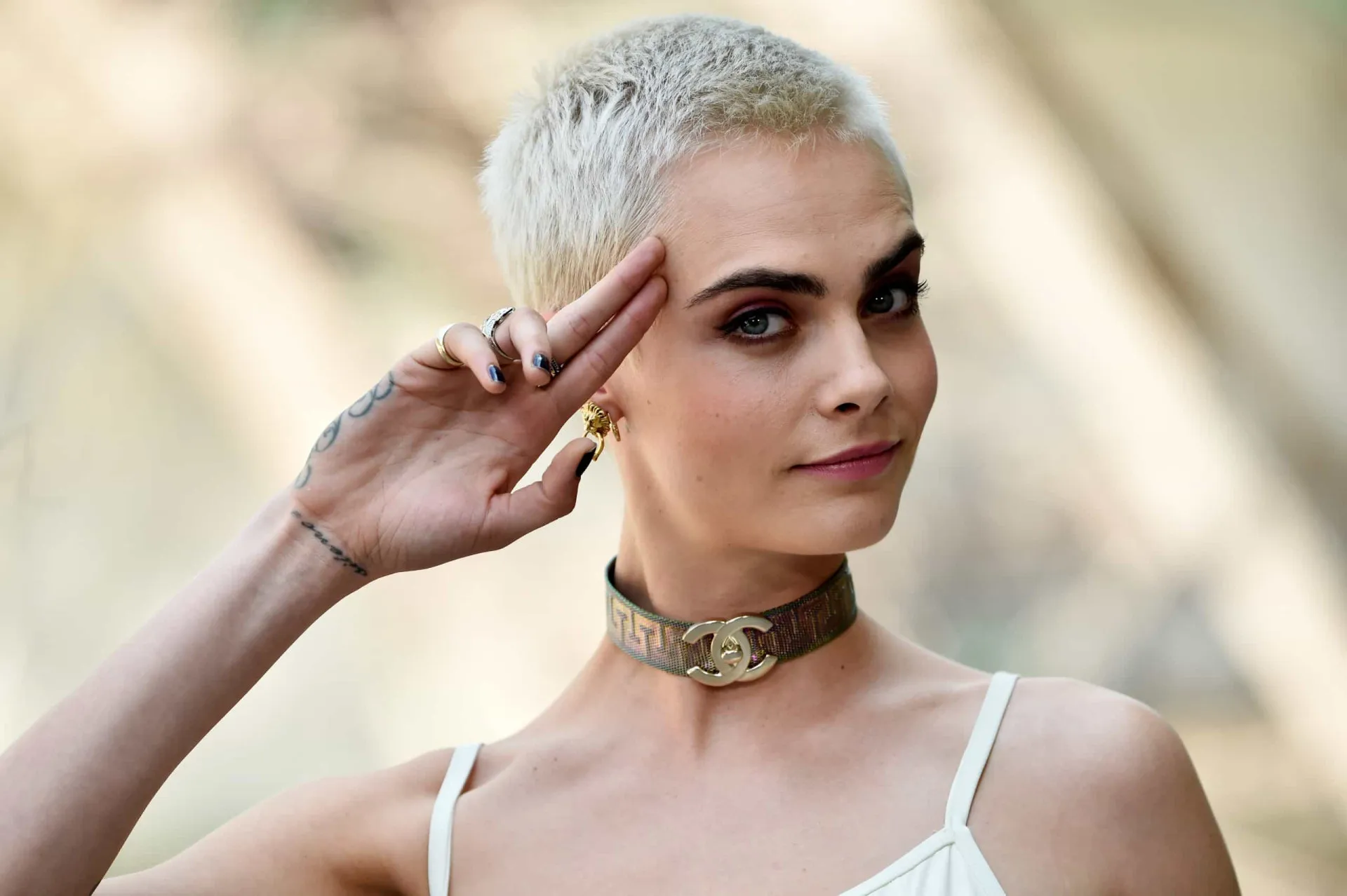 Cara Delevingne em um evento, com um olhar determinado e forte.