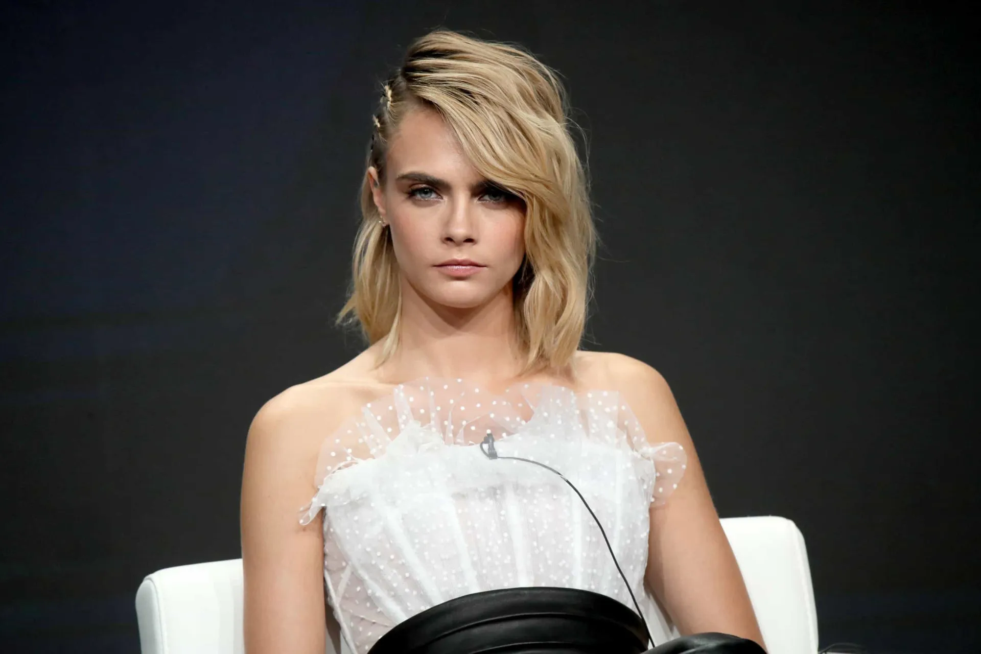 Cara Delevingne com seu visual icônico, olhando de forma desafiadora para a câmera.
