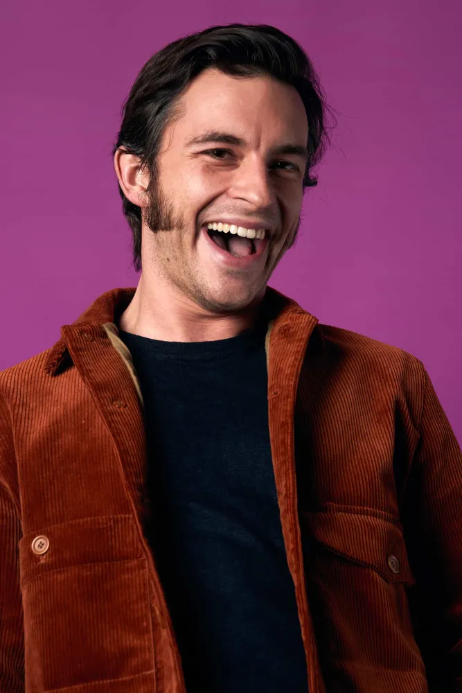 Jonathan Bailey posando com confiança e um olhar determinado.