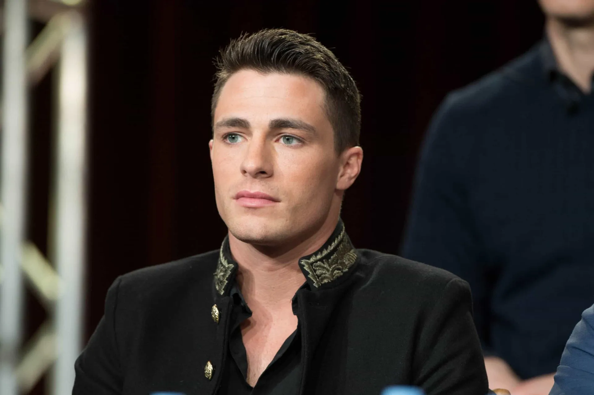 Colton Haynes, astro da série 'Arrow', com um olhar sério e marcante.