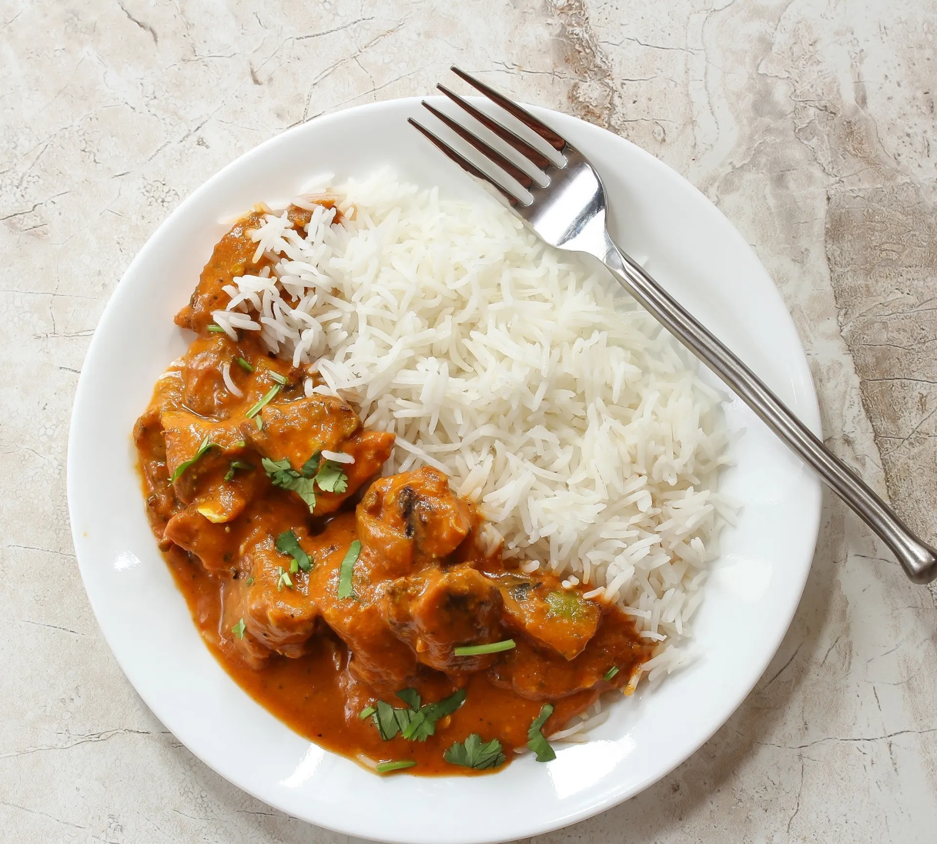 Close-up do molho cremoso do tikka masala, mostrando sua textura rica.