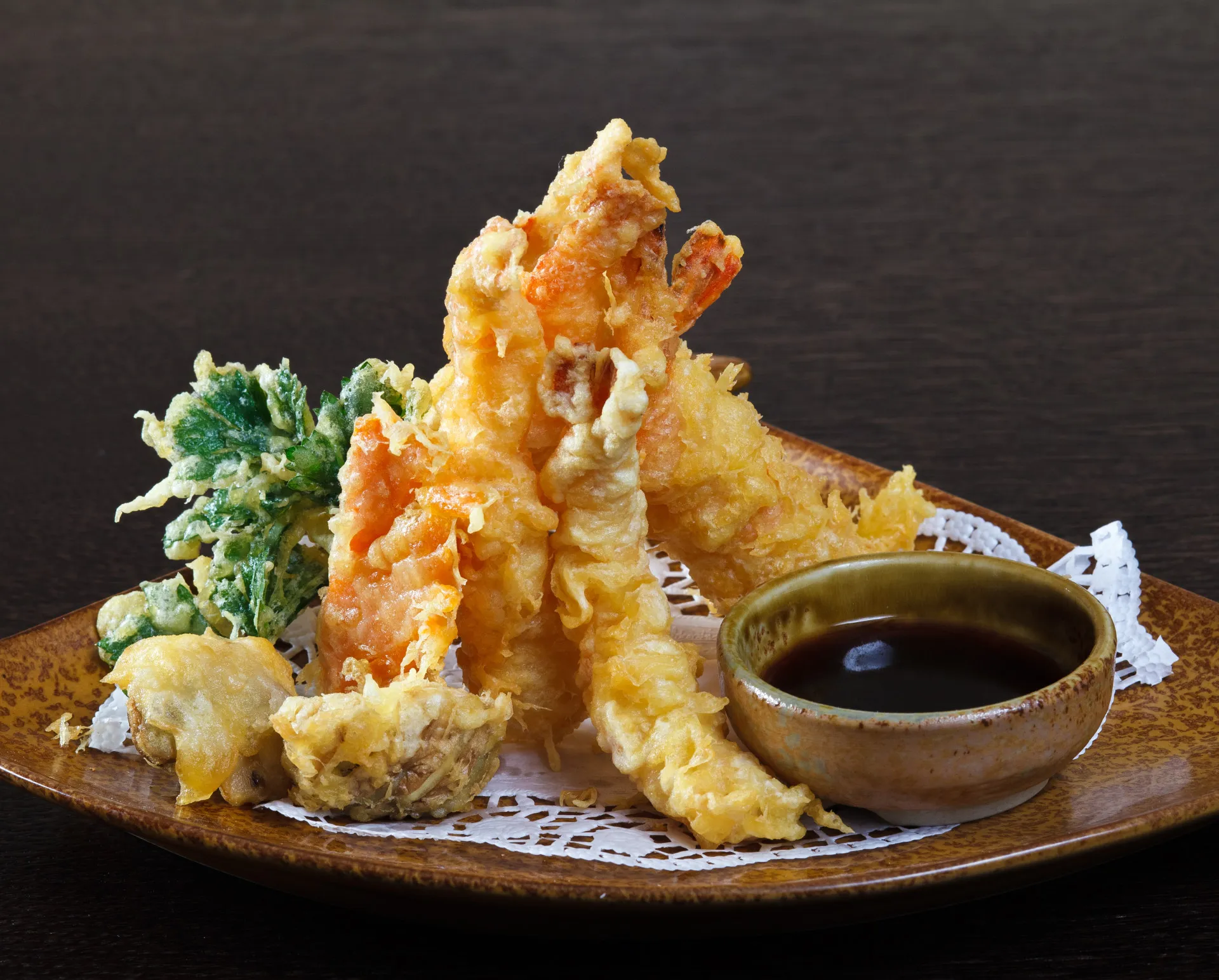 Prato de tempura japonês, com camarões e vegetais fritos em uma massa leve.