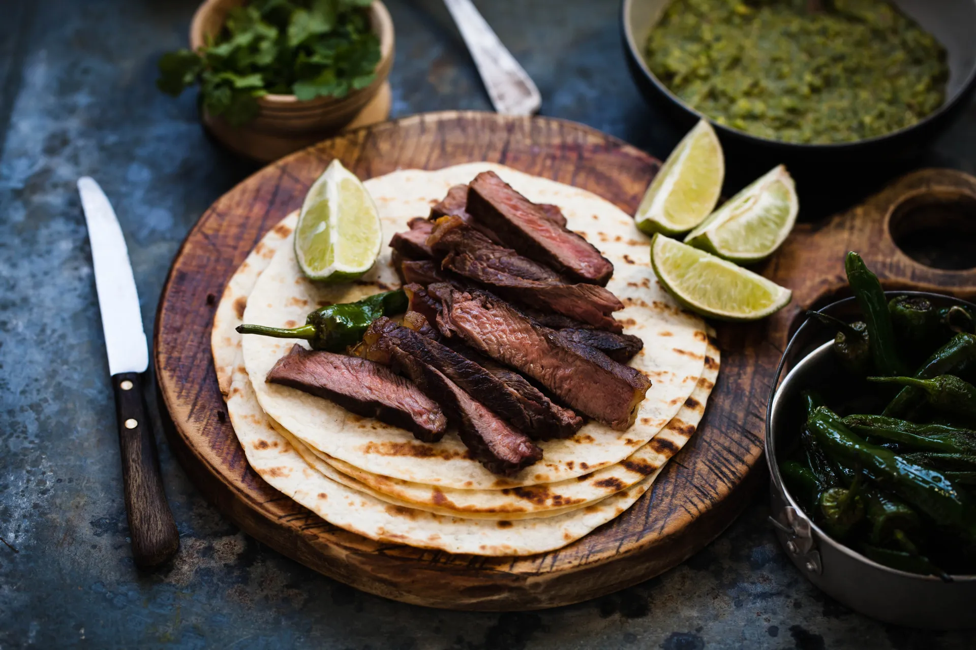 Uma frigideira de ferro quente com fajitas de carne e pimentões coloridos.