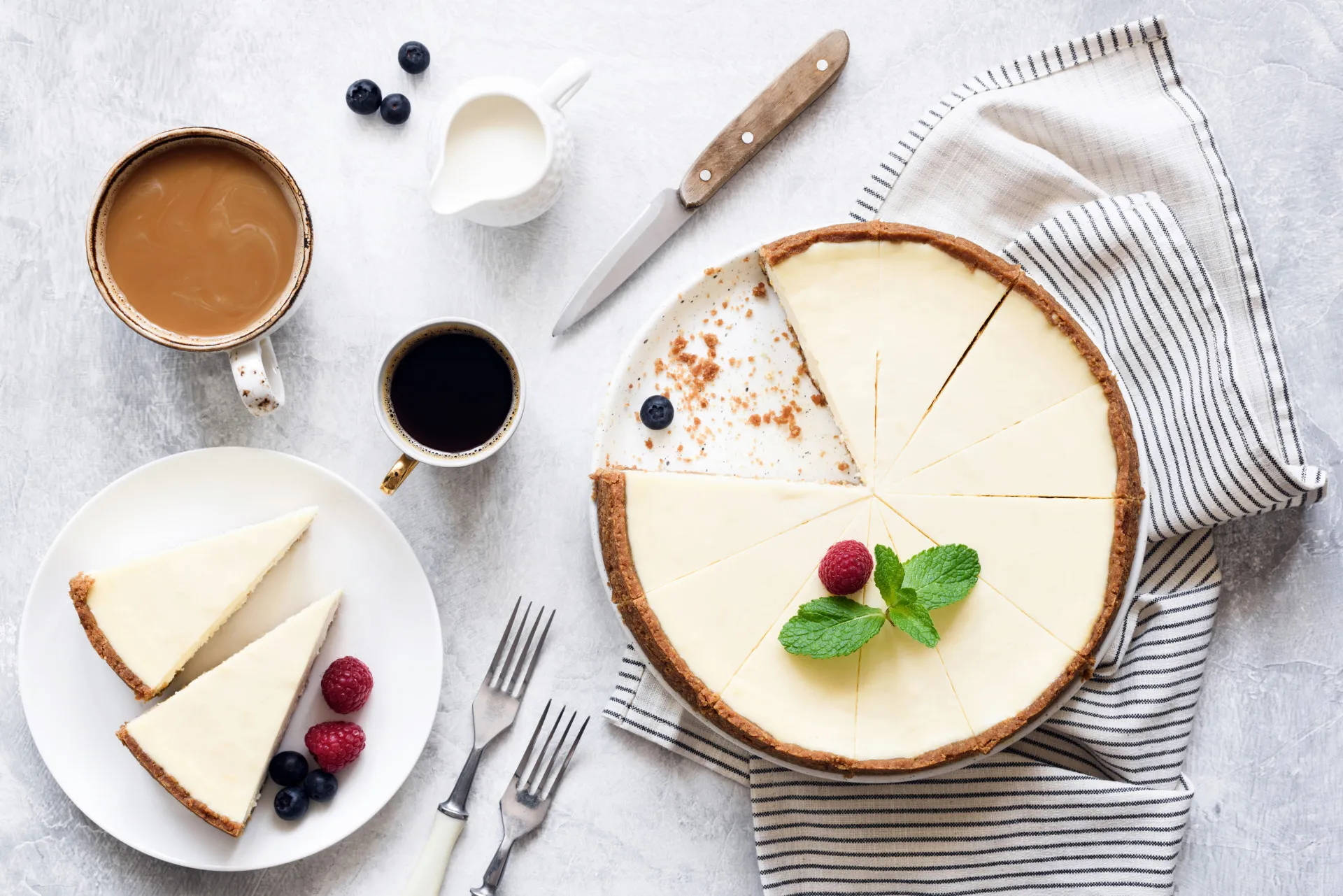 Uma fatia cremosa de cheesecake com cobertura de frutas vermelhas em um prato.