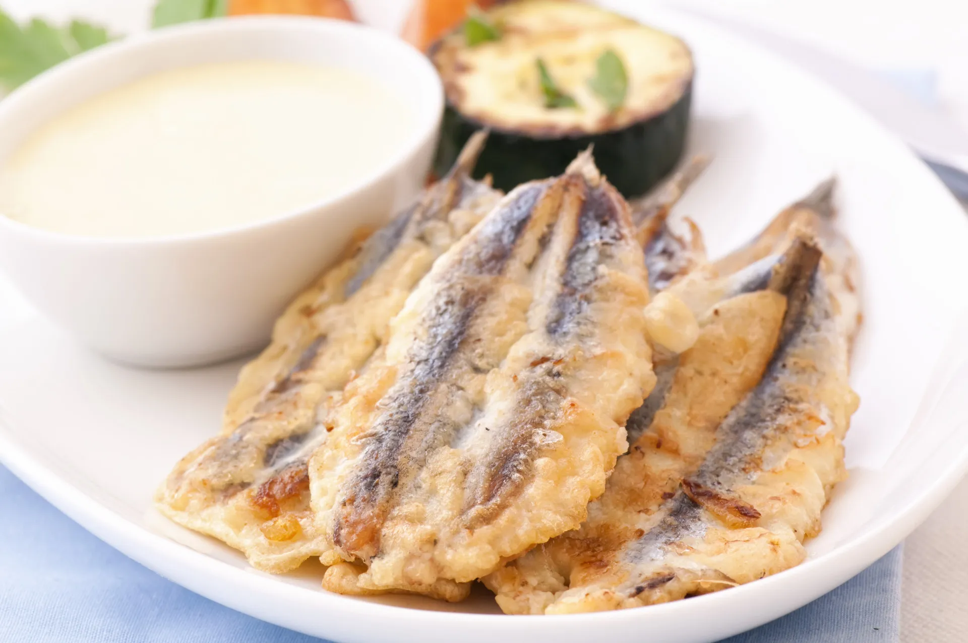 Prato com anchovas fritas, mostrando a tradição portuguesa de peixes fritos pequenos.