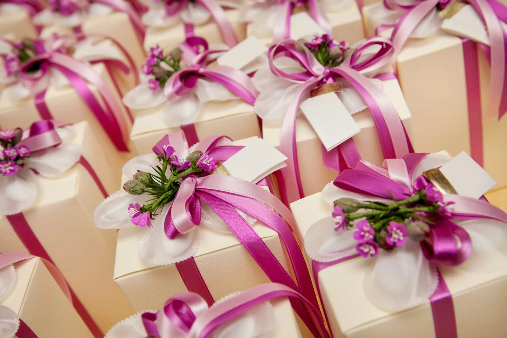 Bem-casados embrulhados em papel crepom com uma fita de cetim, prontos para serem distribuídos.