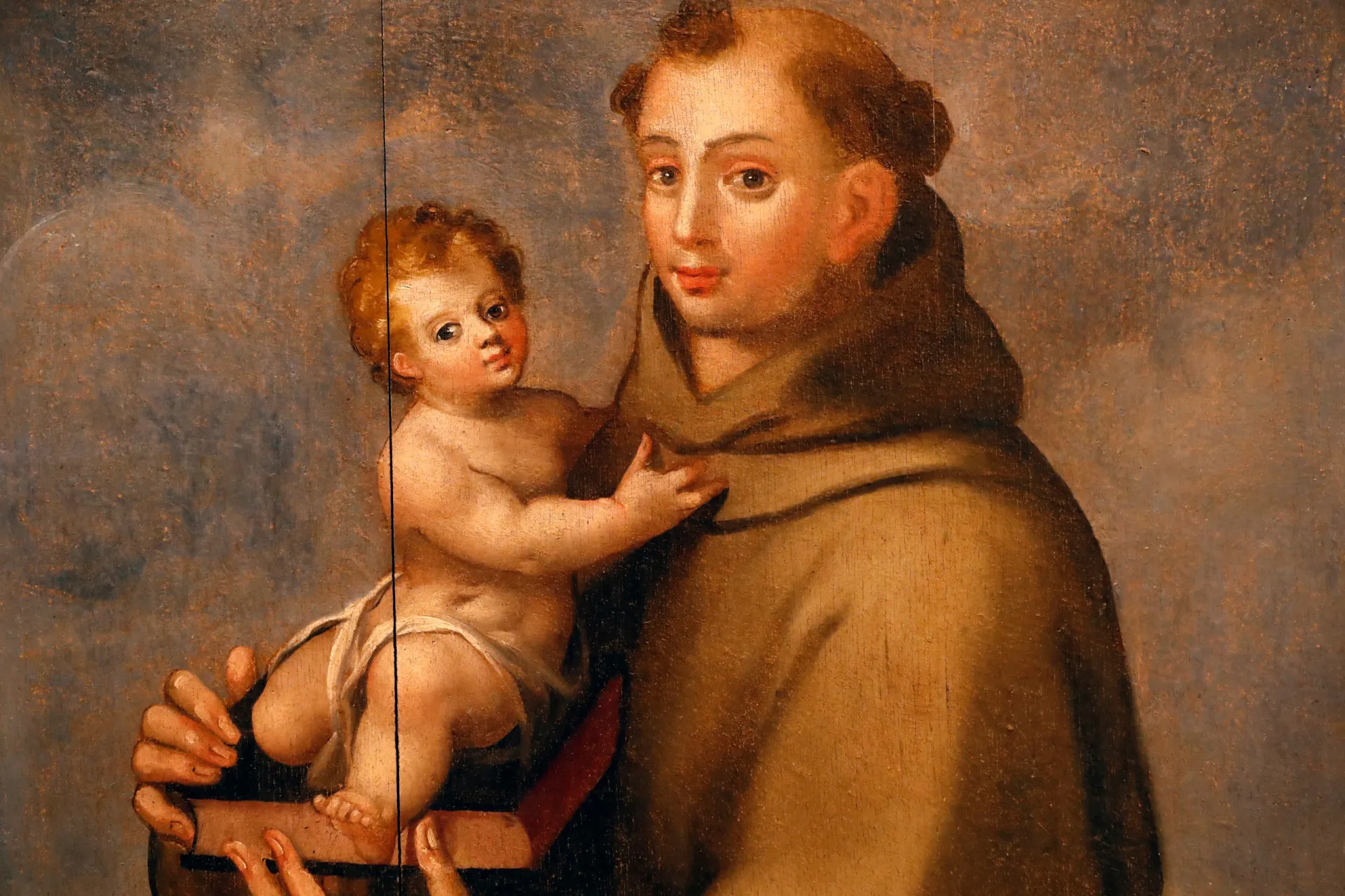 Estátua de Santo Antônio segurando o menino Jesus, uma representação clássica do santo.