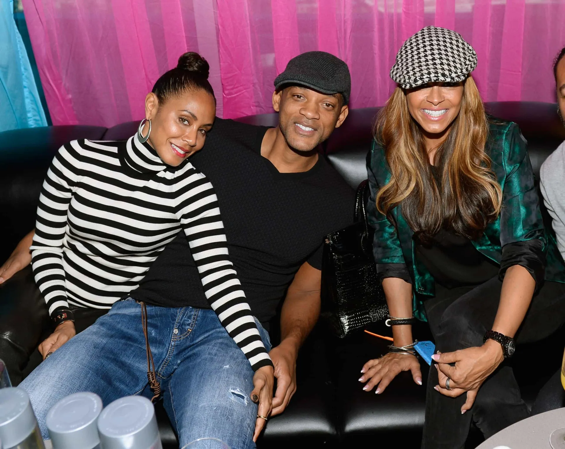 Jada Pinkett Smith e Sheree Fletcher sentadas à mesa, conversando de forma íntima e séria.