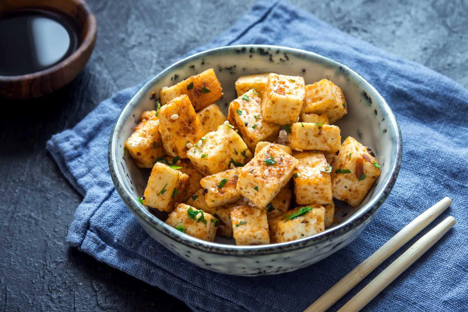 Tofu grelhado com legumes em uma frigideira, mostrando uma refeição colorida e saudável.
