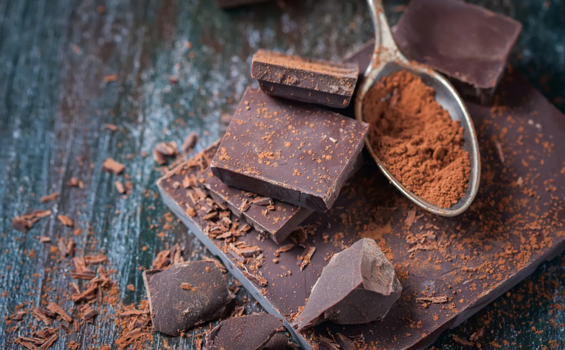 Pedaços de chocolate amargo com alto teor de cacau em uma superfície de madeira.