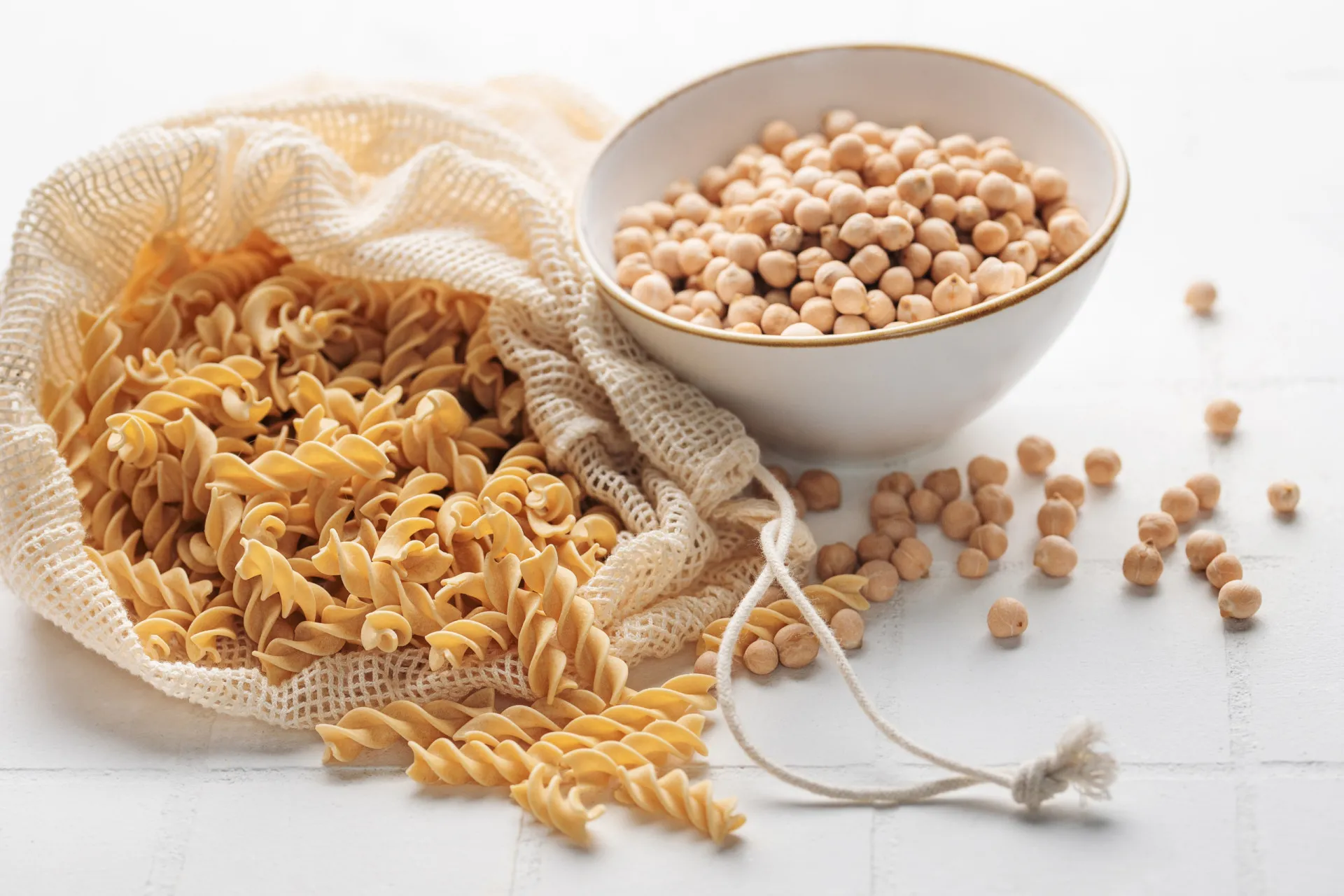 Macarrão tipo fusilli feito de farinha de lentilha vermelha, com uma cor alaranjada.