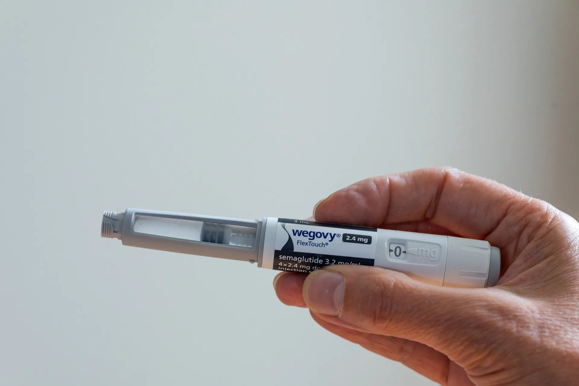 Uma caneta aplicadora do medicamento Wegovy ao lado de uma fita métrica.
