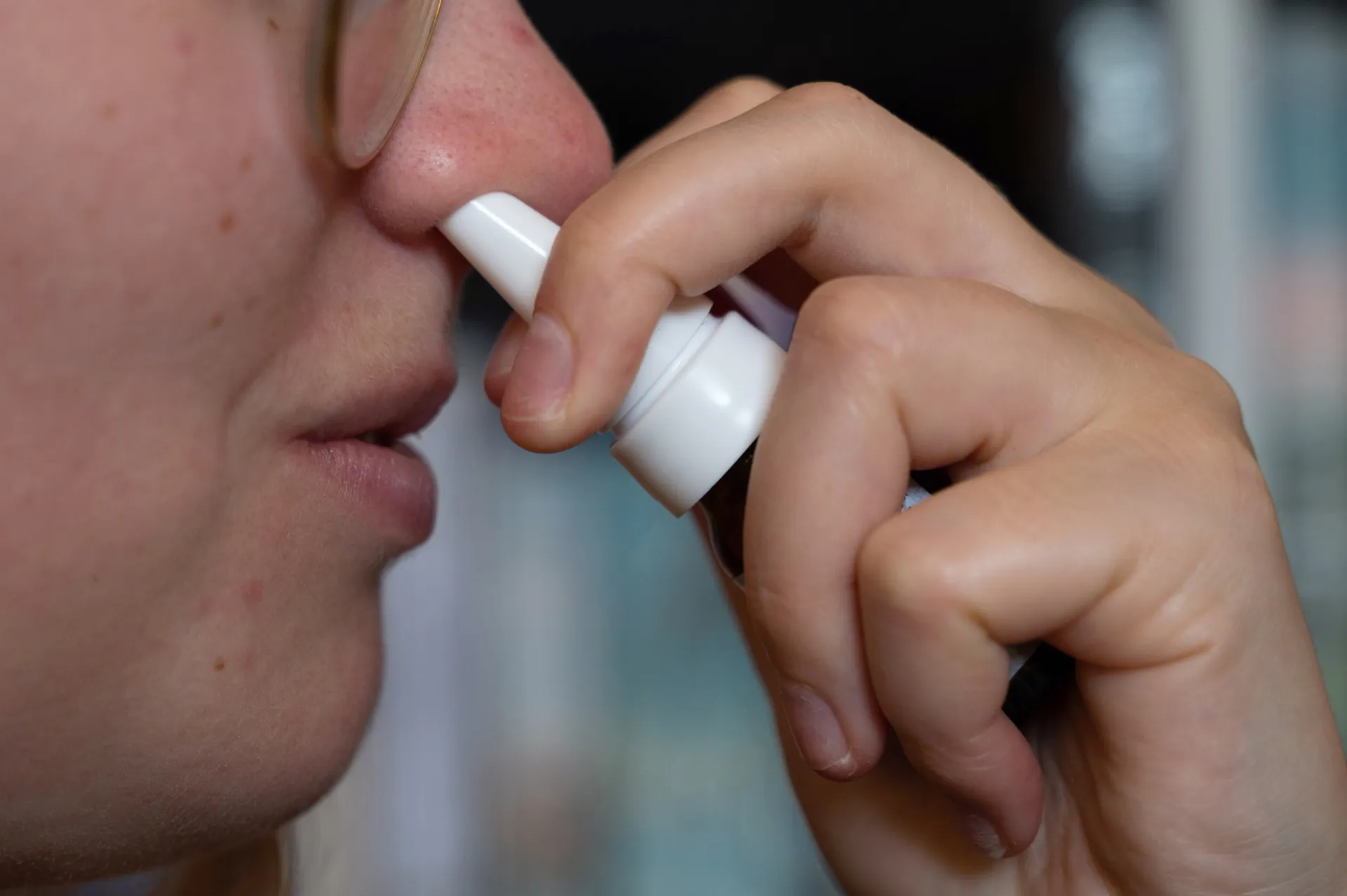 Uma pessoa usando um spray nasal, demonstrando a facilidade de administração do Neffy.