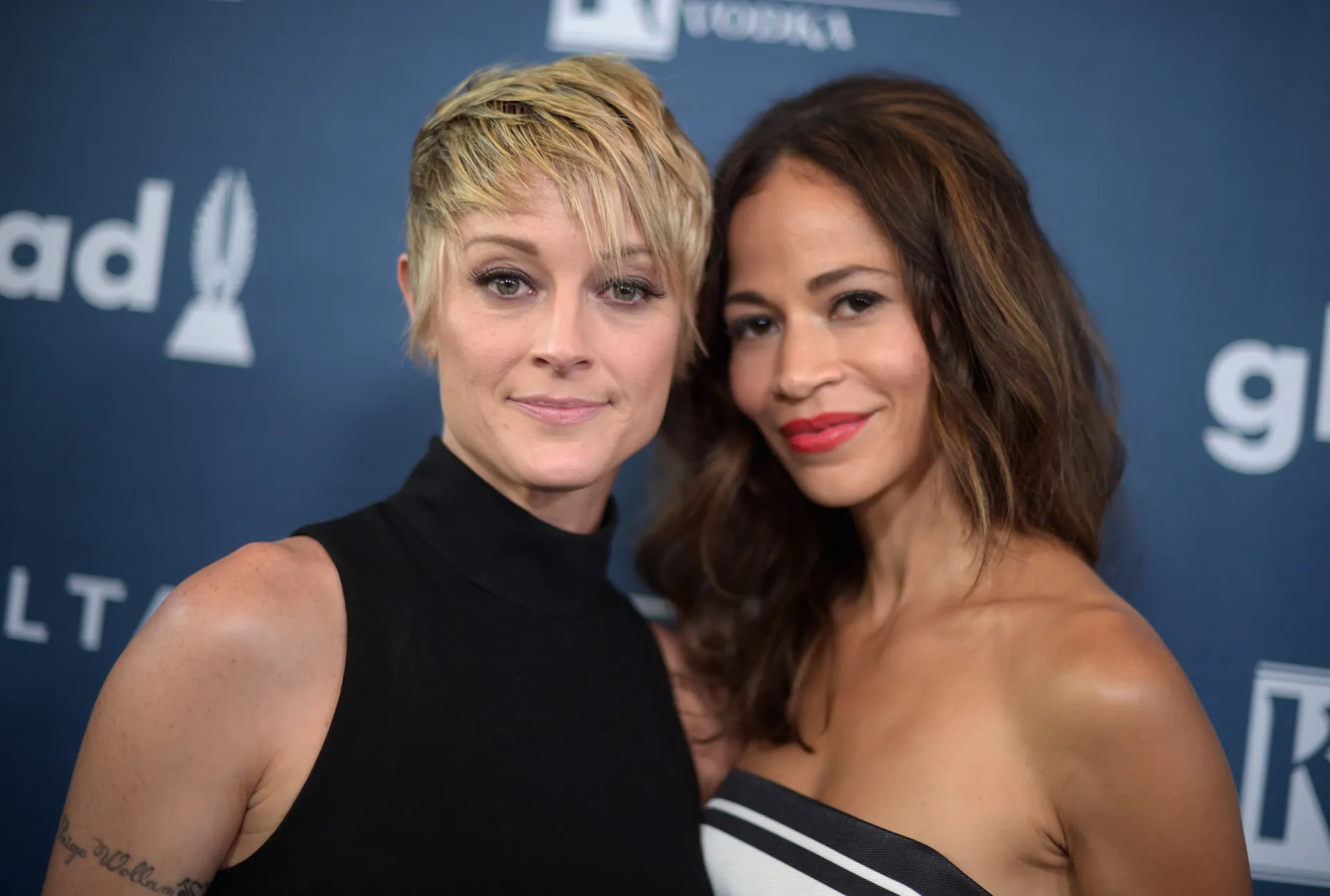 Stef e Lena, o casal de mães da série 'The Fosters', abraçadas com seus filhos.