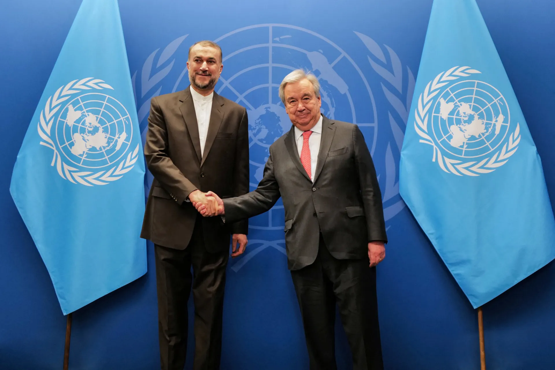 Diplomatas em uma mesa de negociação, com a bandeira da ONU ao fundo.