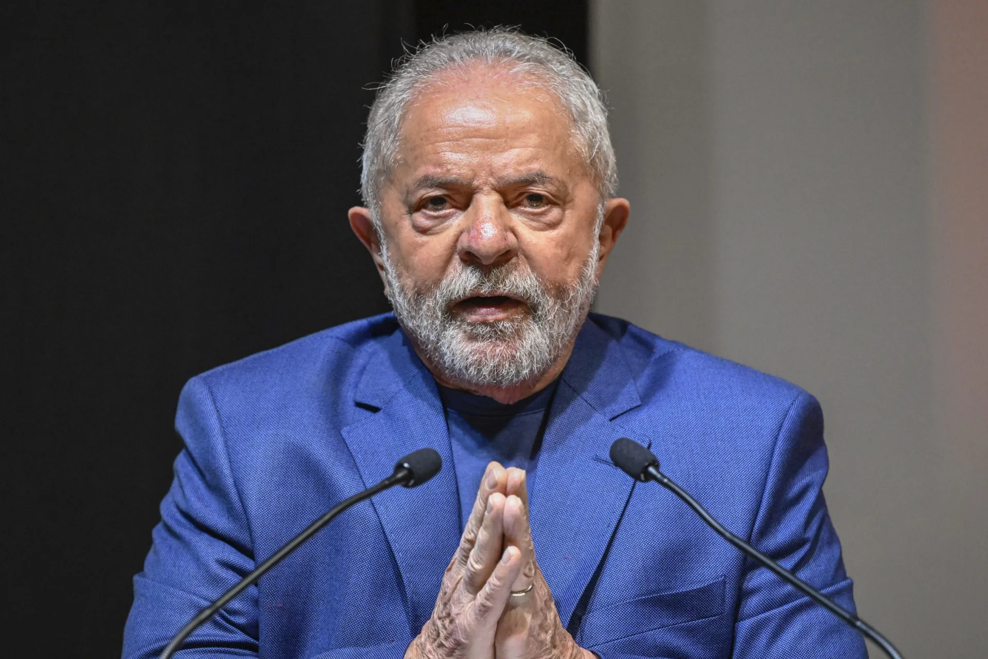 Presidente Lula em um evento, com uma expressão séria, simbolizando o peso das promessas feitas.