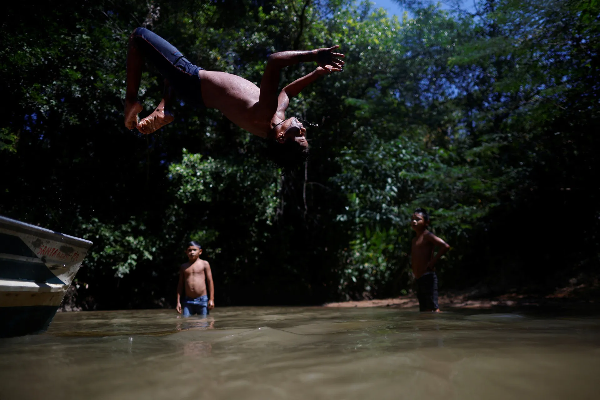 Crianças Munduruku brincando felizes em um rio na Amazônia, em completa harmonia com a natureza.