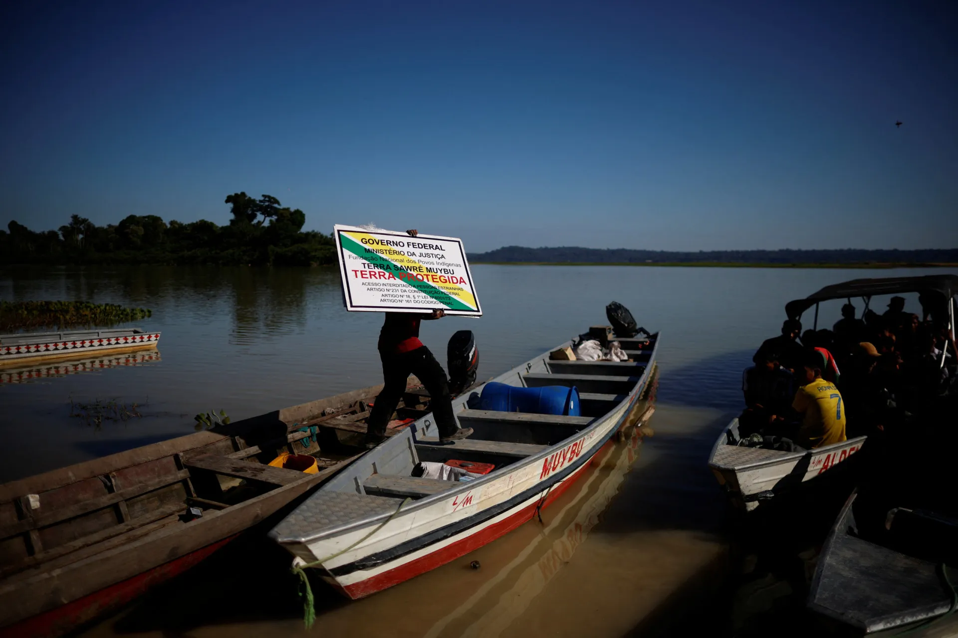 Área de floresta desmatada para a construção de uma barragem, com o rio ao fundo.