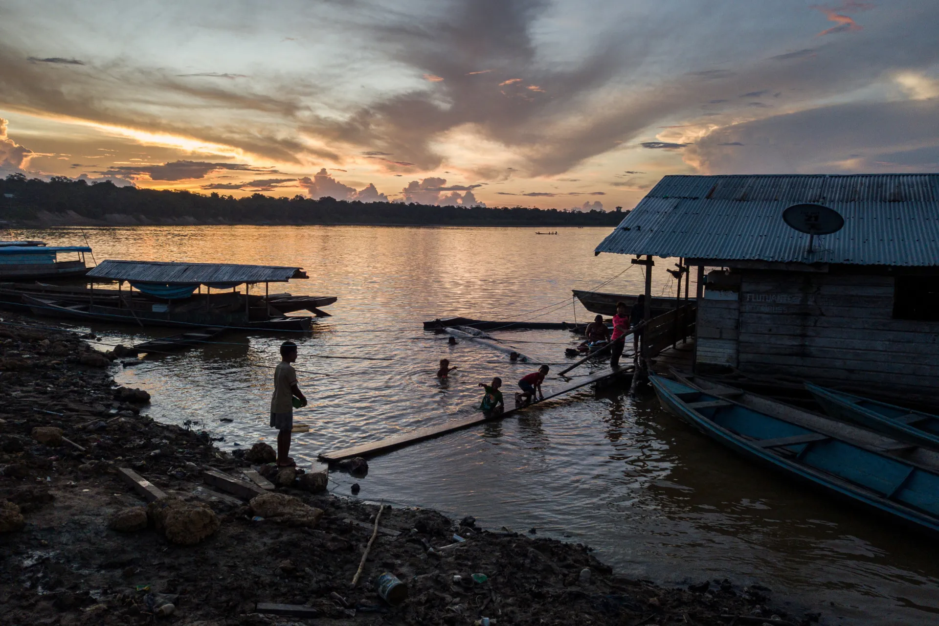 Pôr do sol sobre o rio Amazonas, com a silhueta da floresta, evocando a beleza e a fragilidade do ecossistema.