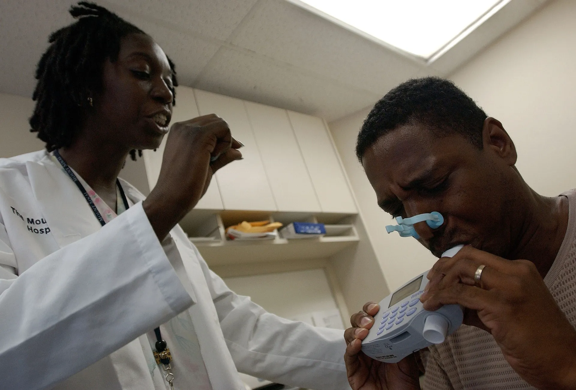 Médico auscultando os pulmões de um paciente, indicando monitoramento de doenças respiratórias.