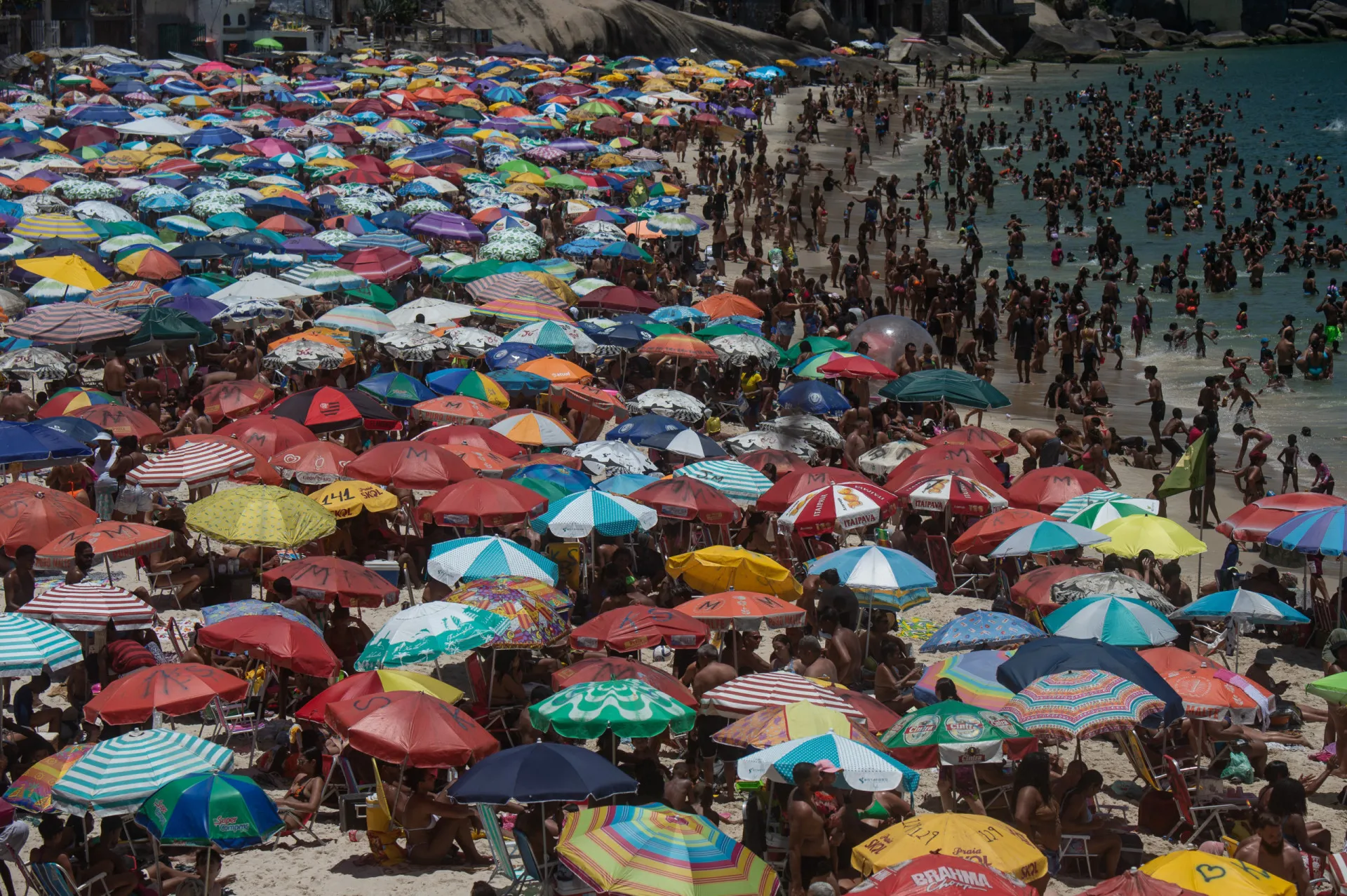 Praia do Rio de Janeiro lotada de pessoas durante uma intensa onda de calor.