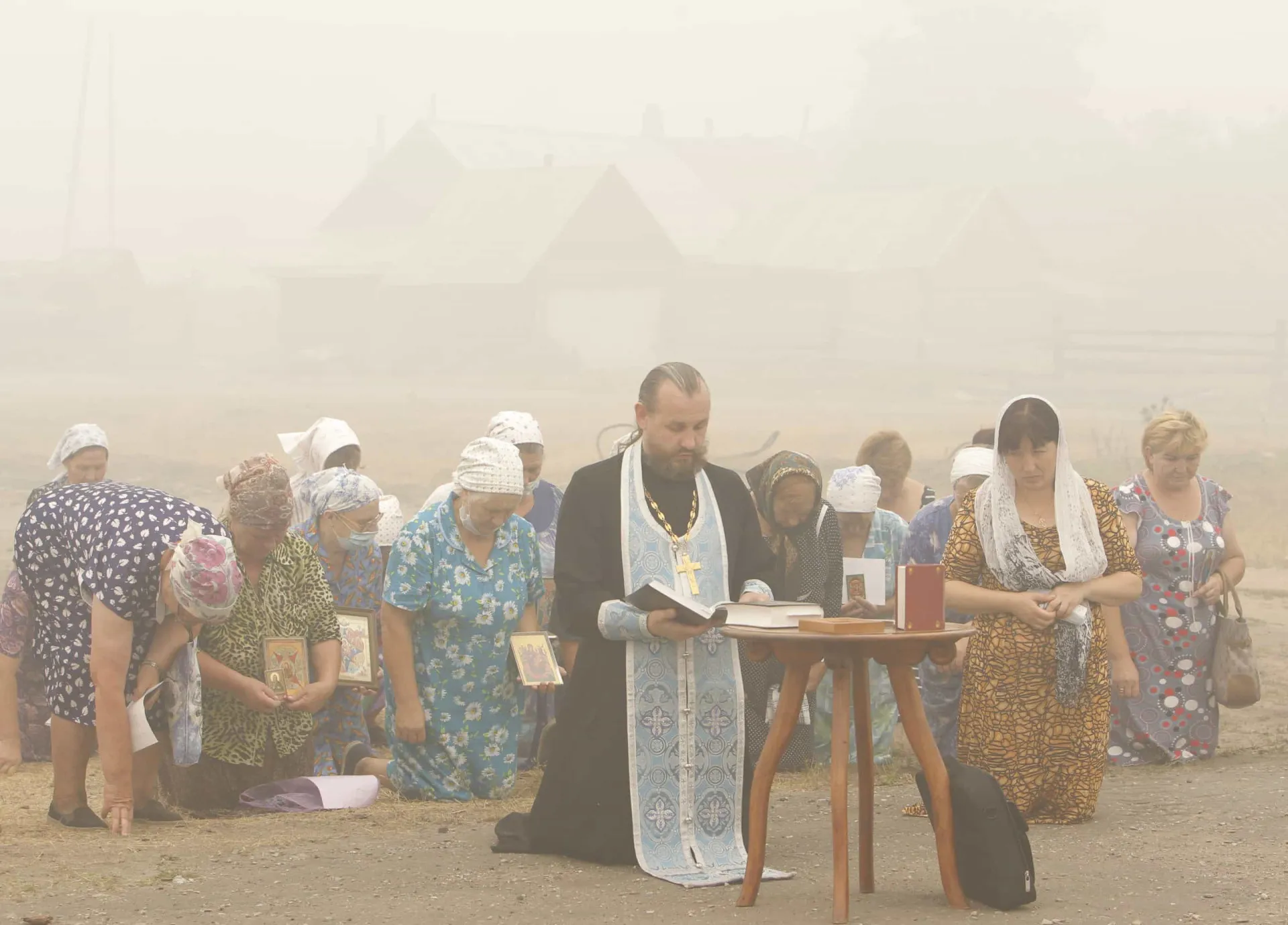 Pessoas rezando em uma igreja ortodoxa na Rússia durante a onda de calor e incêndios de 2010.