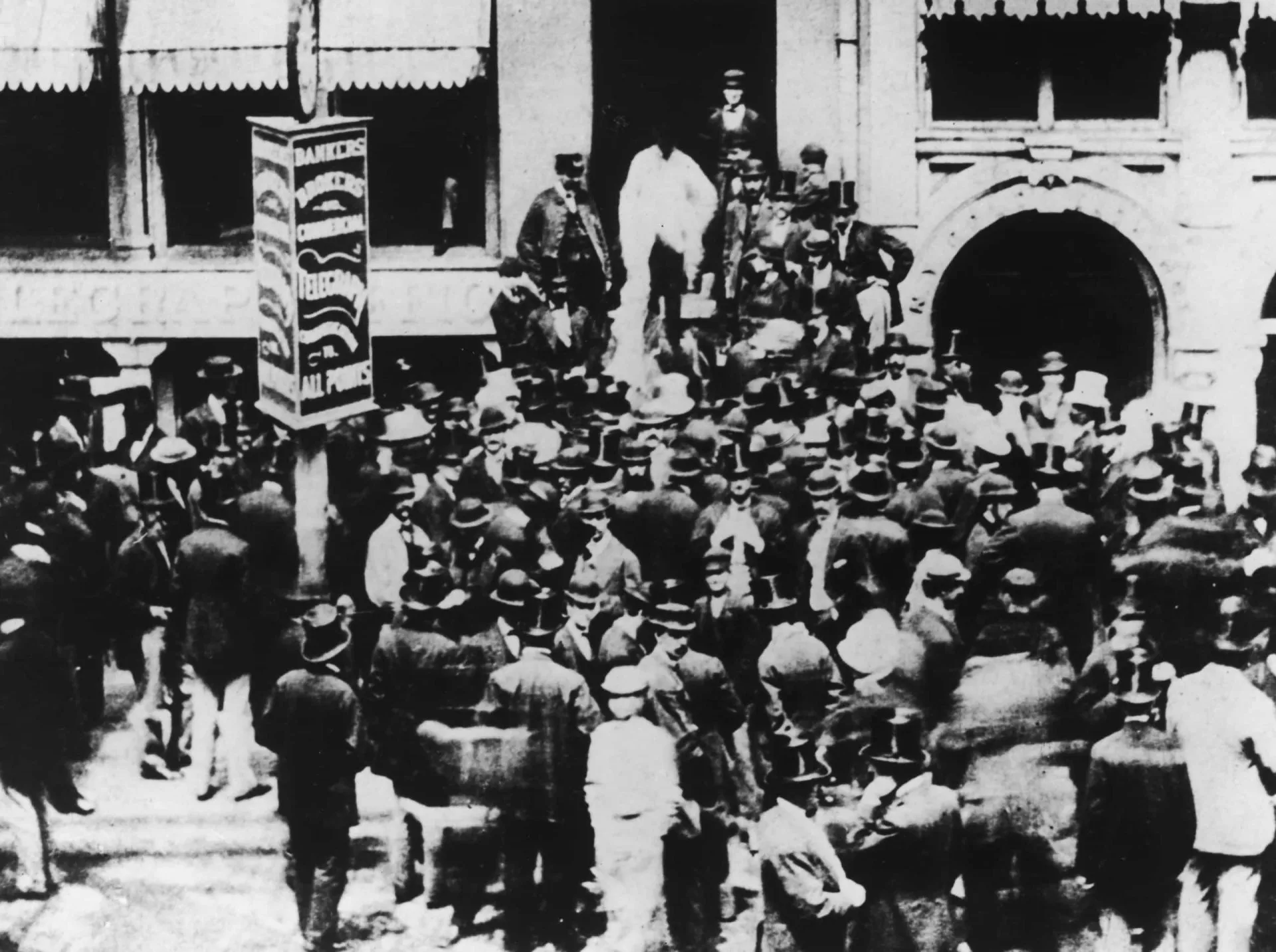 Foto em preto e branco de uma rua movimentada em Nova York no final do século XIX.