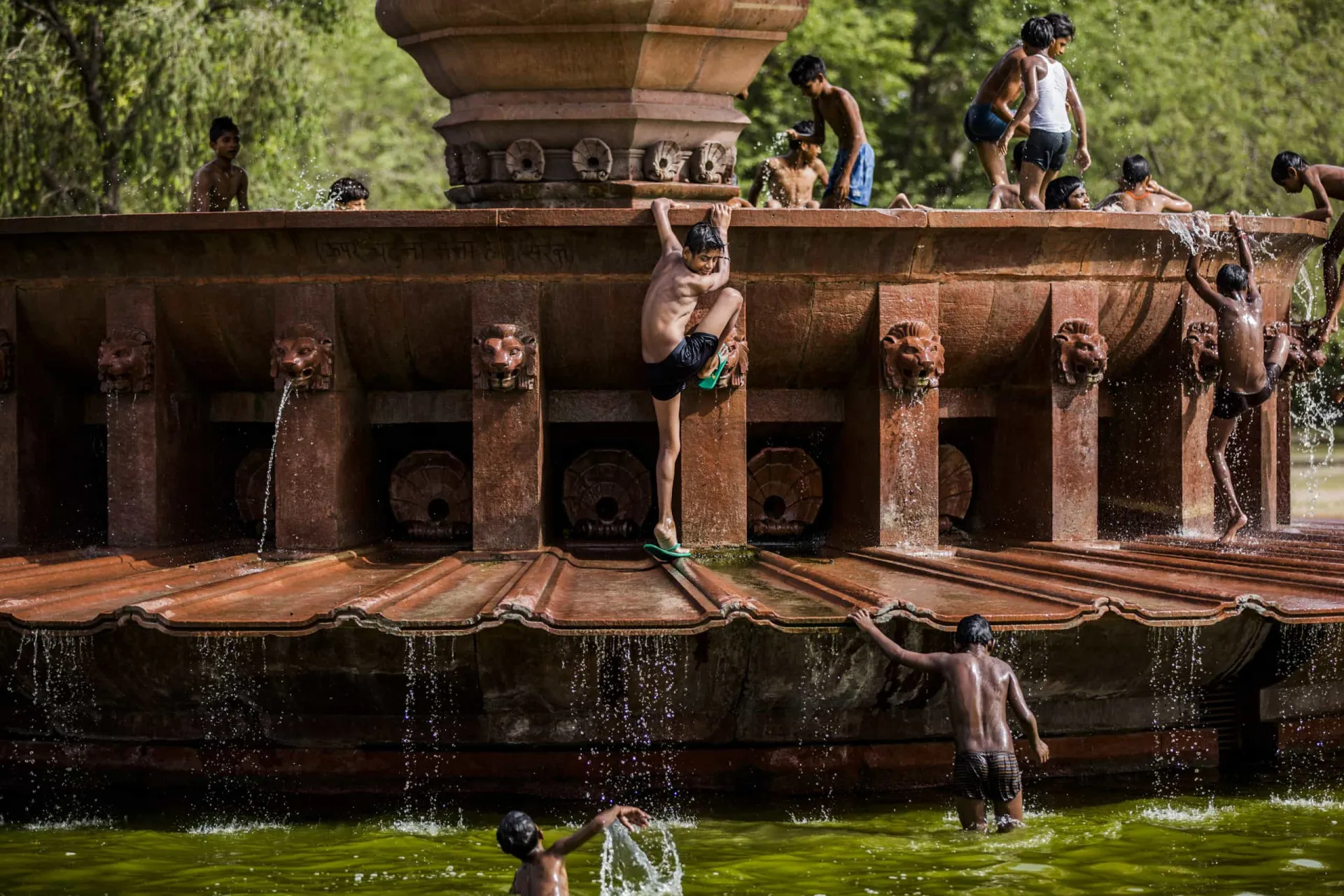 Homem indiano derramando água sobre a cabeça para se refrescar do calor intenso.