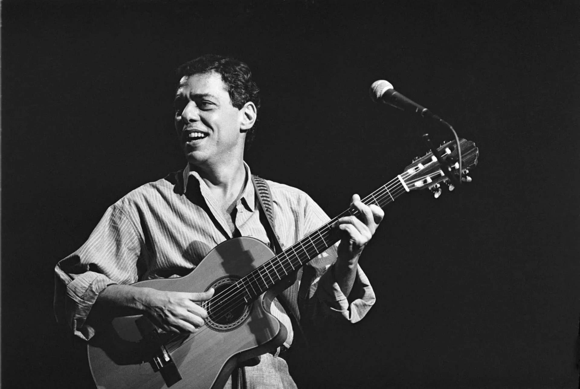 Um close do rosto de Chico Buarque, pensativo, em preto e branco.