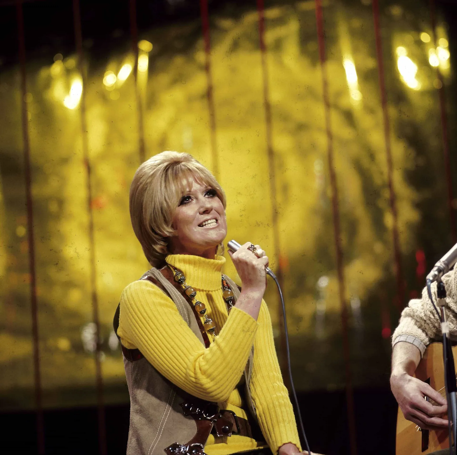 A cantora Dusty Springfield com seu icônico penteado loiro e maquiagem dos anos 60.