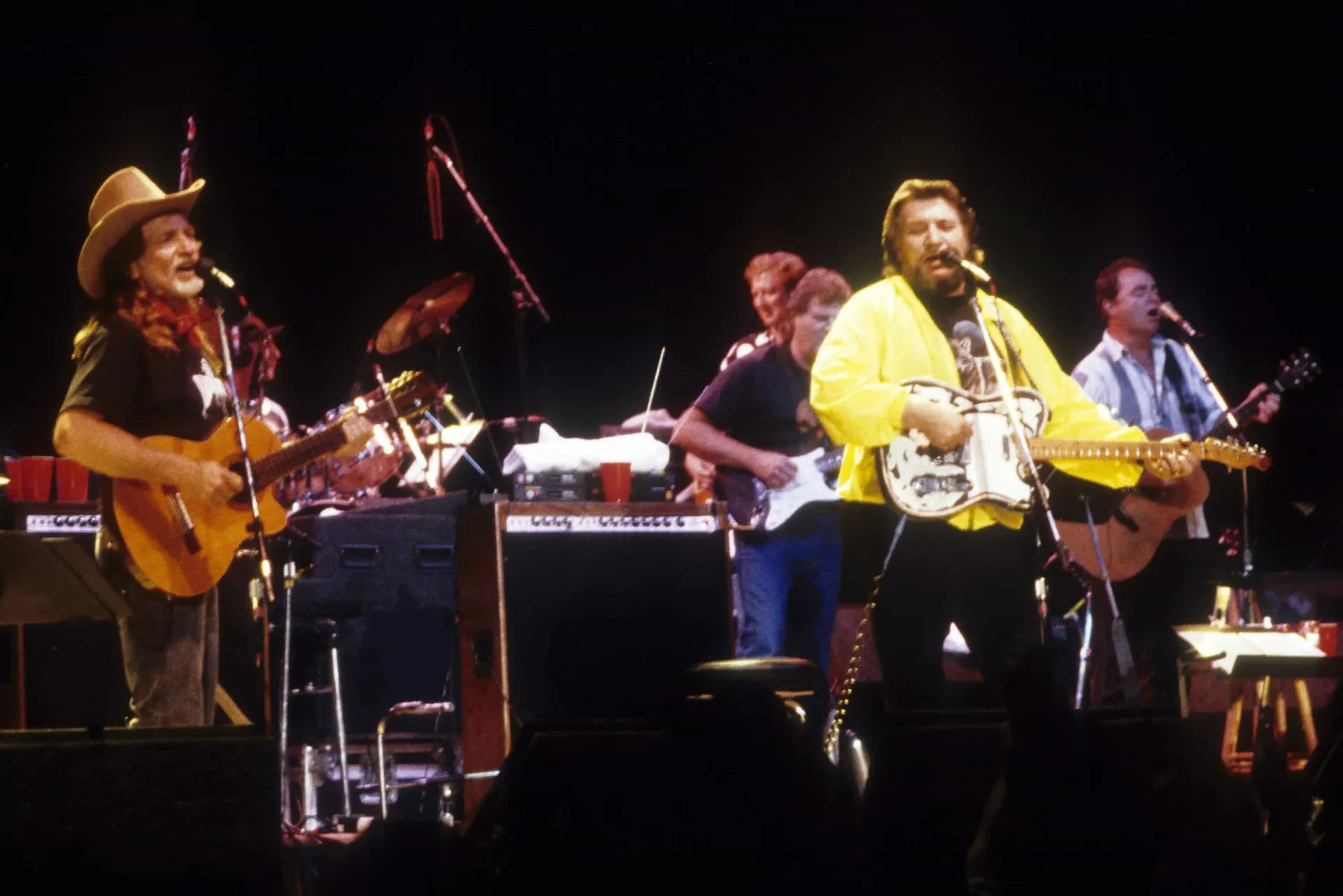 Os ícones da música country Waylon Jennings e Willie Nelson juntos, sorrindo.