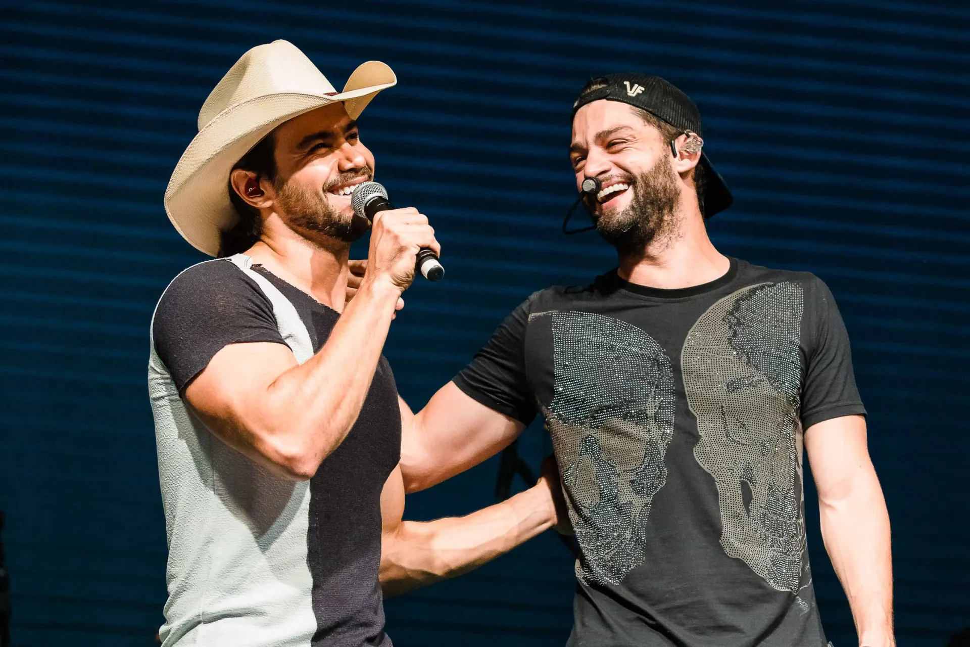 A dupla Munhoz e Mariano posando para uma foto em um evento.