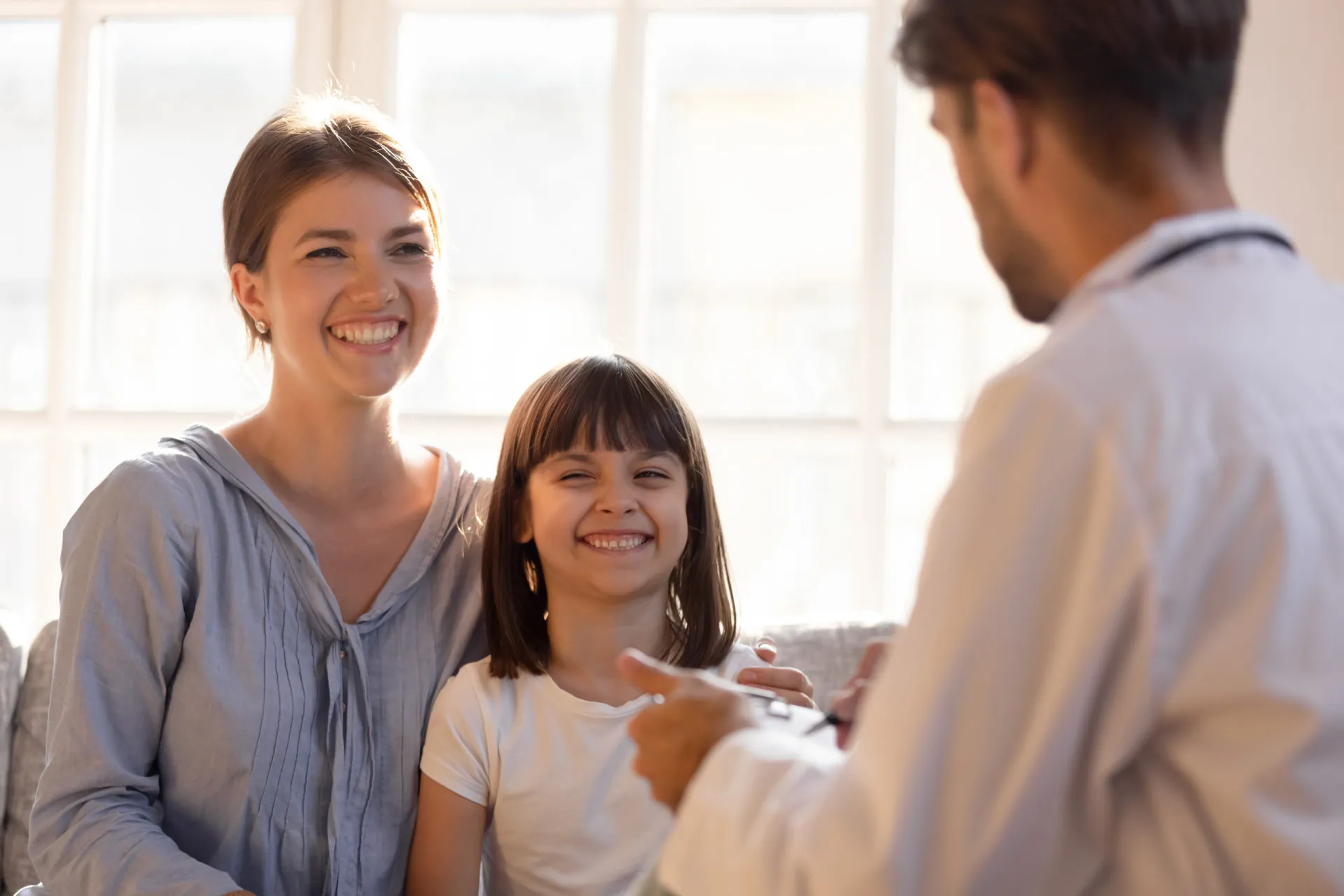 Pais conversando com um médico sobre a saúde de seu filho adolescente.