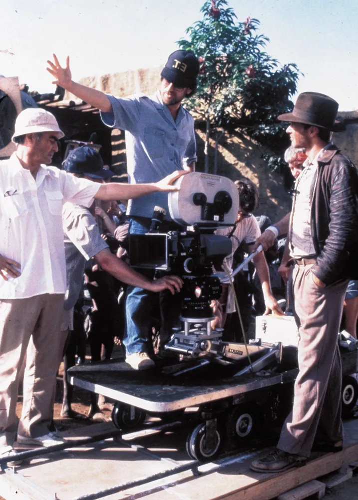 Cena do filme 'Indiana Jones e o Templo da Perdição' com Harrison Ford em um ambiente escuro e tenso.