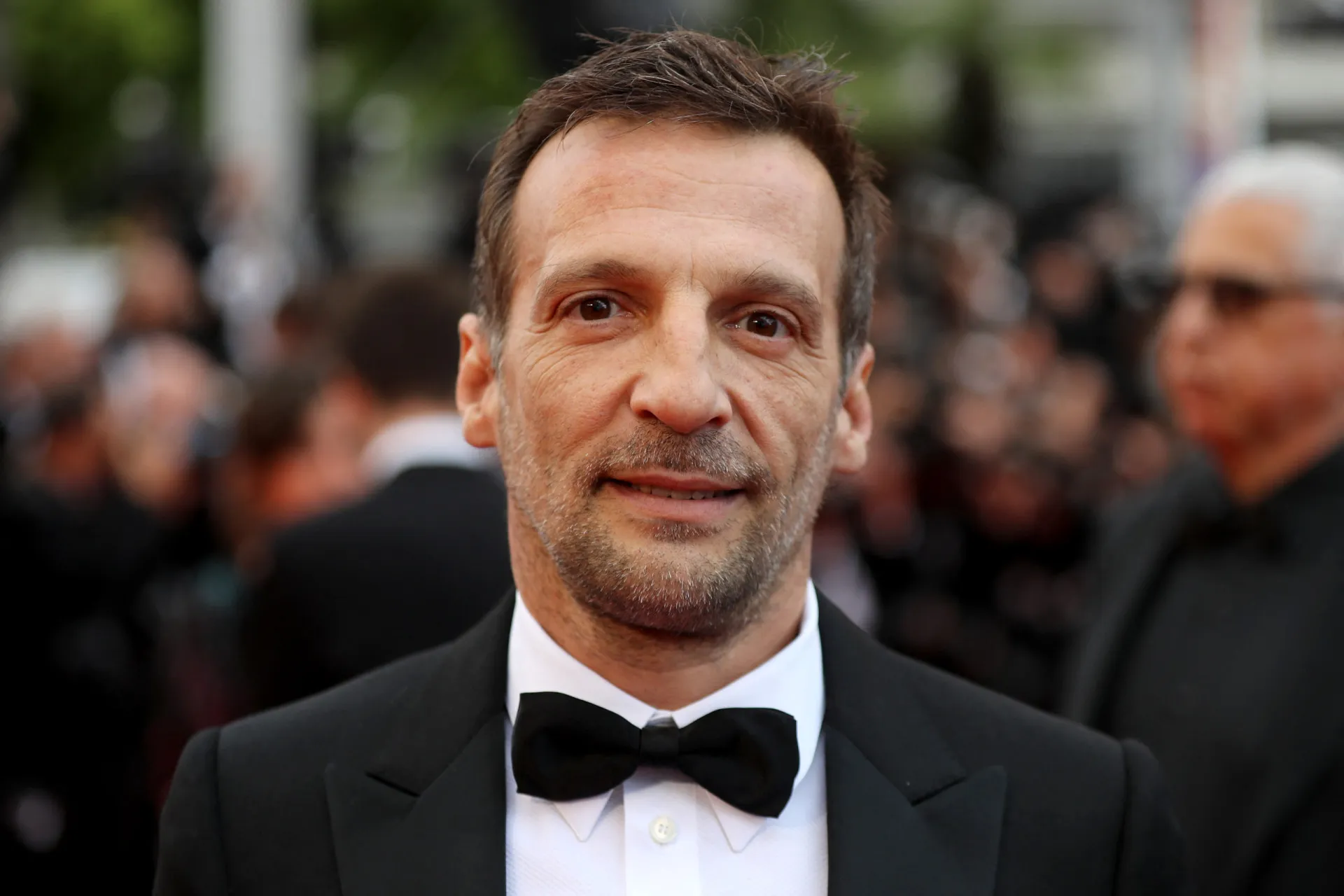 O diretor Mathieu Kassovitz gesticulando em uma entrevista, parecendo frustrado ao falar sobre o filme.