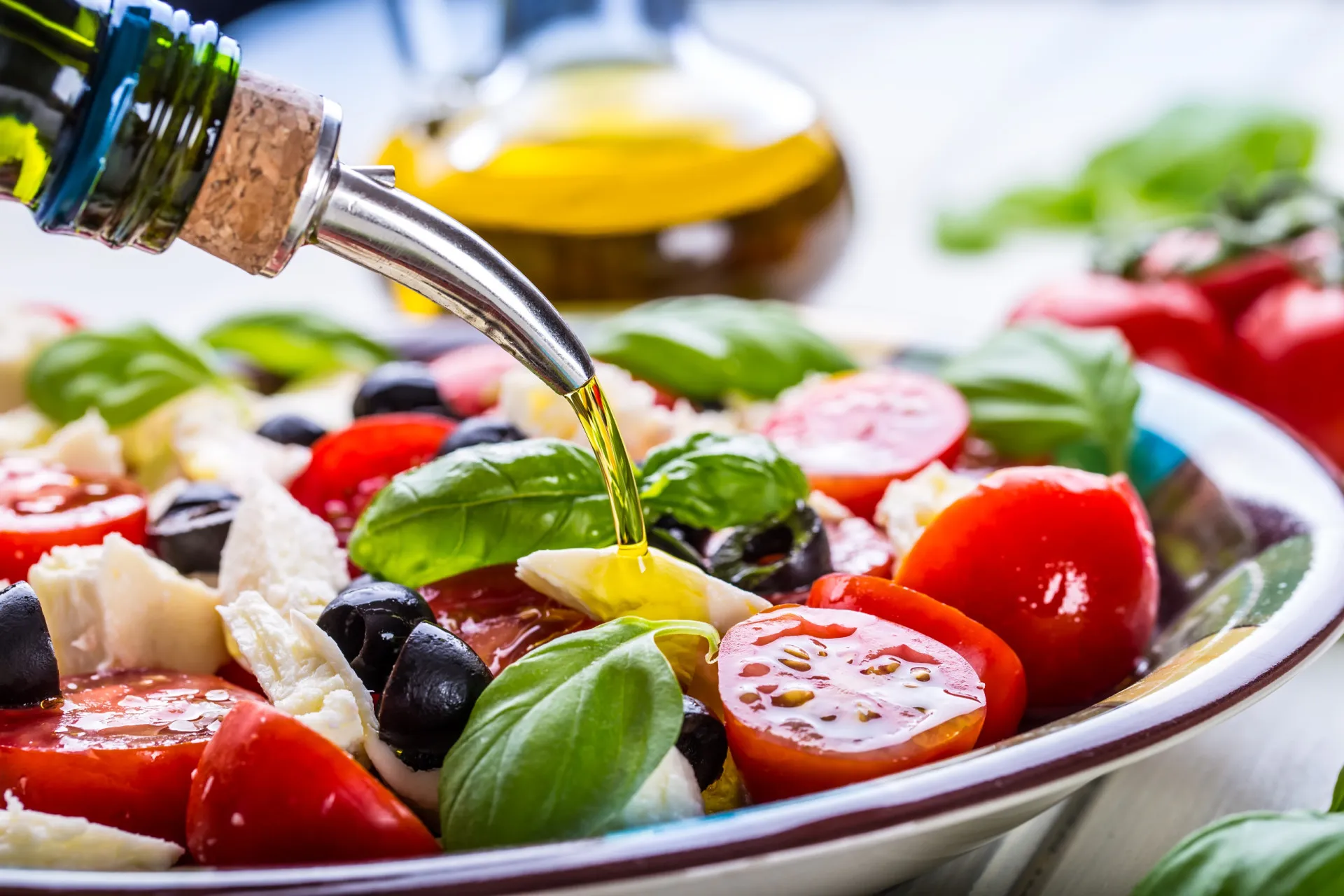 Azeite de oliva extravirgem sendo derramado sobre uma salada fresca, destacando sua cor dourada.