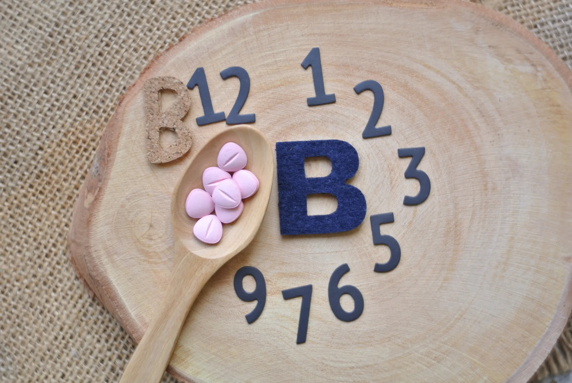 Símbolos de vitaminas e minerais com um sinal de alerta, indicando deficiência.
