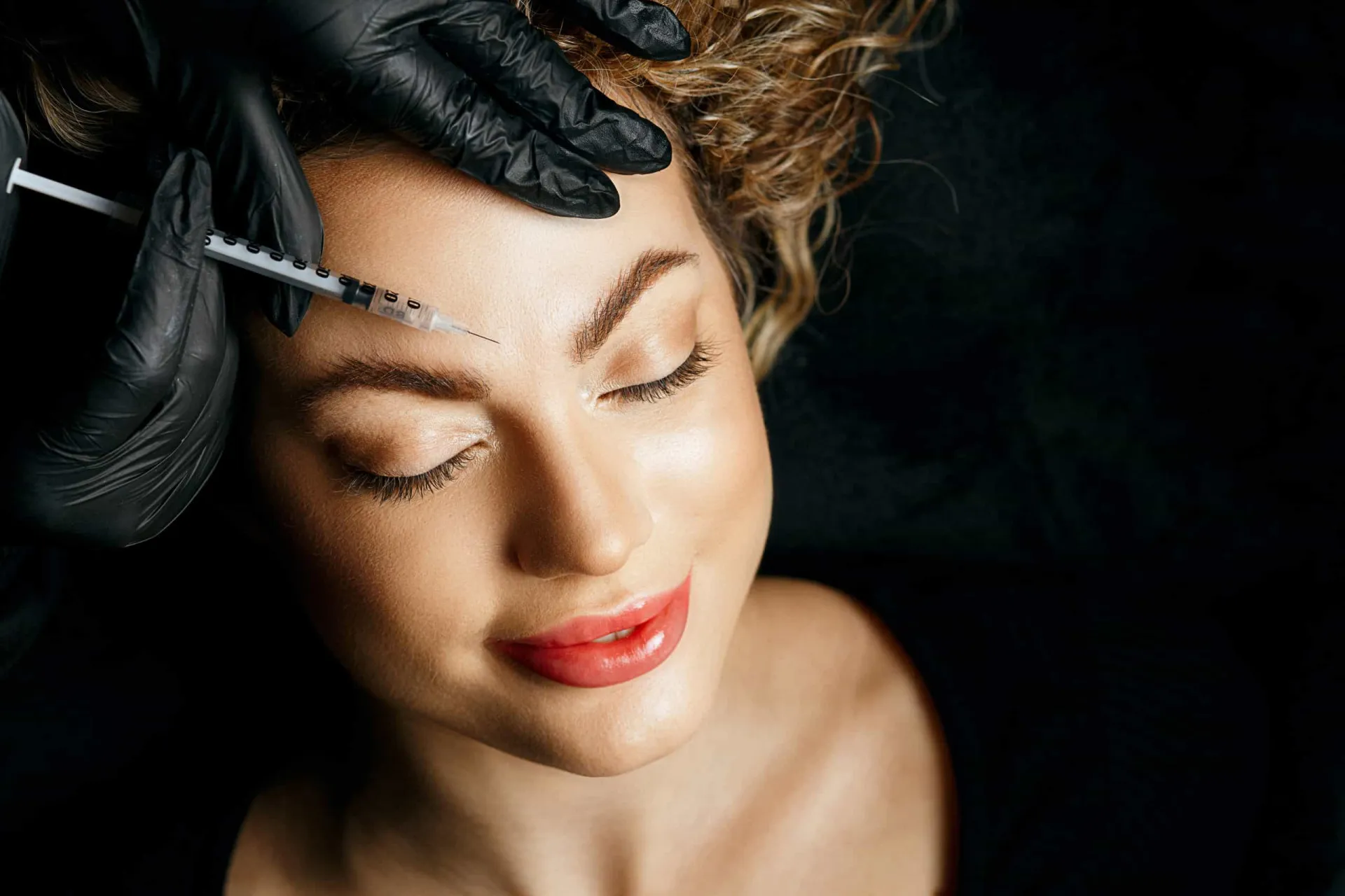 Profissional da saúde preparando uma seringa de Botox em um ambiente clínico e estéril.