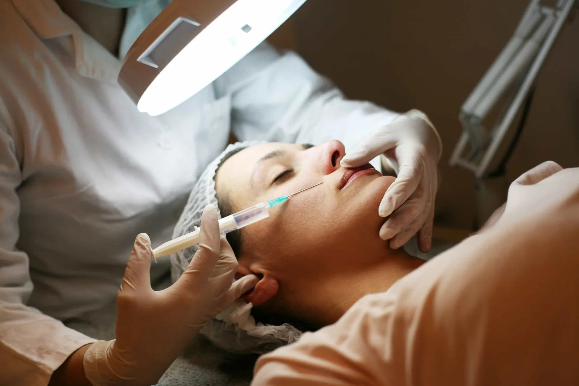 Médico dermatologista explicando o procedimento de Botox para uma paciente em seu consultório.