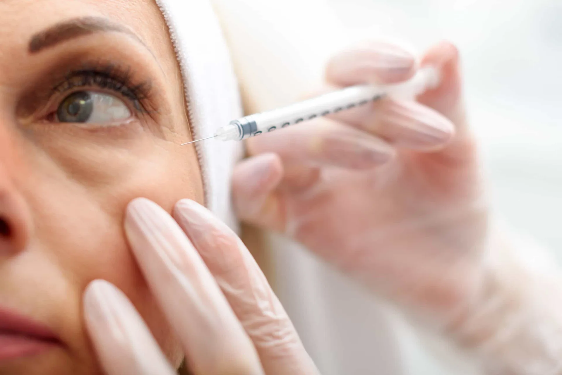 Mulher olhando-se no espelho com uma expressão calma após o procedimento de Botox.